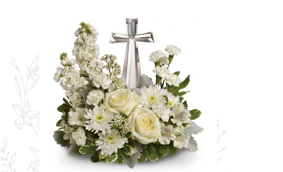 Teleflora's Divine Peace Bouquet - An elegant display of faith and divine peace, this beautiful arrangement will comfort the bereaved in a truly thoughtful and respectful way. An exquisite crystal cross is surrounded by a bed of lovely blossoms. It is sure to be appreciated and always remembered.  A fragrant mix of pure white blooms - including roses, alstroemeria, stock, carnations and waxflower - is accented with dusty miller and variegated pittosporum around an exclusive Crystal Cross keepsake. 