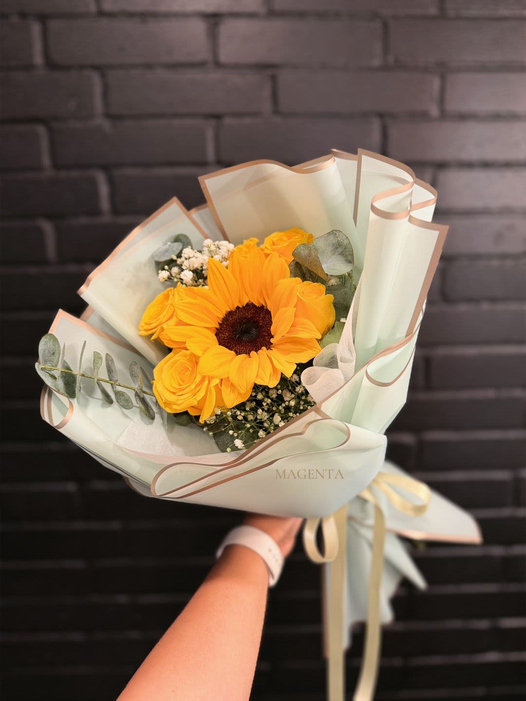 GOLDEN BLOOM - Celebrate Yellow Flower Day on March 21 with this radiant hand-tied bouquet of sunflower, yellow roses, baby’s breath, and fresh eucalyptus, wrapped in premium Korean paper.  Brighten hearts and spaces with a modern, sophisticated touch. Perfect to gift or simply say “thinking of you”.