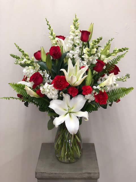 Red &amp; White In Love Bouquet - Red and white floral assortment that is sure to take their breath away! A dozen red roses surrounded with other red and white blooms such as carnations, stock, snap dragons, etc... to make this magnificent bouquet  