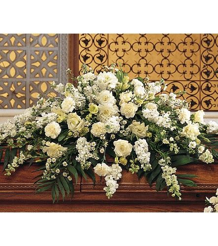 TF194-1 Pure White Casket Spray - This casket spray with its array of white carnations, larkspur, asters and stock adds a pure and loving gesture to the service. One casket spray arrives decorated with white carnations, larkspur, lisianthus, asters and stock, and simple foliage. Approximately 45" W x 36" H 