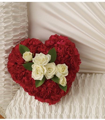 T260-2A A Devoted Heart Casket Insert - Such a simple tribute, this lovely casket bouquet of white roses enclosed in a heart of red carnations is a profoundly moving symbol of never-ending love. The sweet bouquet includes white spray roses surrounded by red miniature carnations formed in the shape of a heart. Approximately 6 3/4" W x 6 1/2" H  