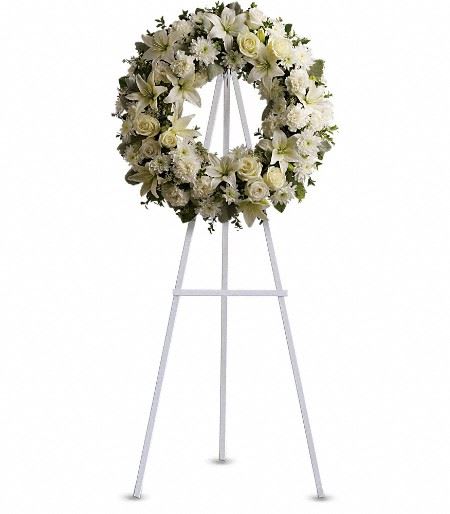 T239-3A Serenity Wreath - A ring of fragrant, bright white blossoms will create a serene display at any funeral or wake. This classic wreath is delivered on an easel, and is a thoughtful expression of sympathy and admiration. A standing wreath created from fresh white flowers such as roses, Asiatic lilies, carnations and cushion spray chrysanthemums - accented with greenery - is delivered on an easel. Approximately 22" W x 22" H 