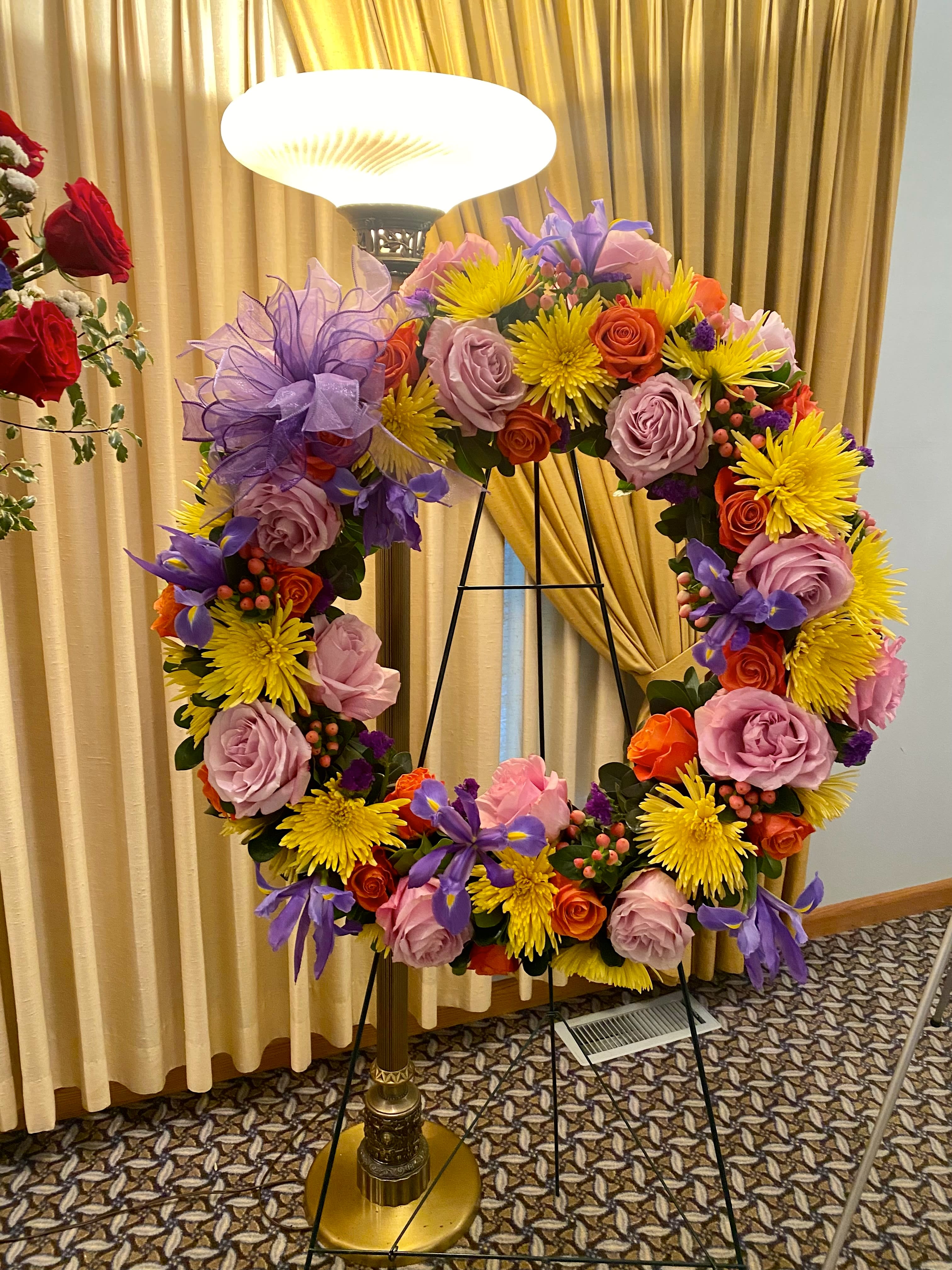 Loving Memory - A lovely mix of beautiful colors and flowers to send in loving memory of someone special~This is a very large 2 foot diameter wreath on a 7 ft easel stand~absolutely stunning &amp; memorable!