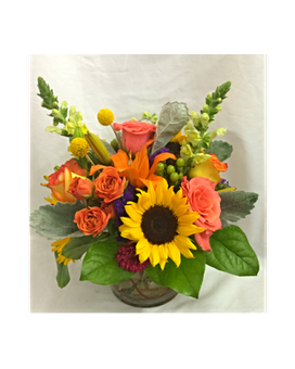 Garden In Paradise - In this hand arranged bouquet you see Sunflowers, yellow Snap Dragons, Roses, orange Spray Roses, organge Lilies and Hypericum Berries in a short 6 inch Cylinder Vase.  All flowers and colors are subject to change due to avilability.    FCF-0231