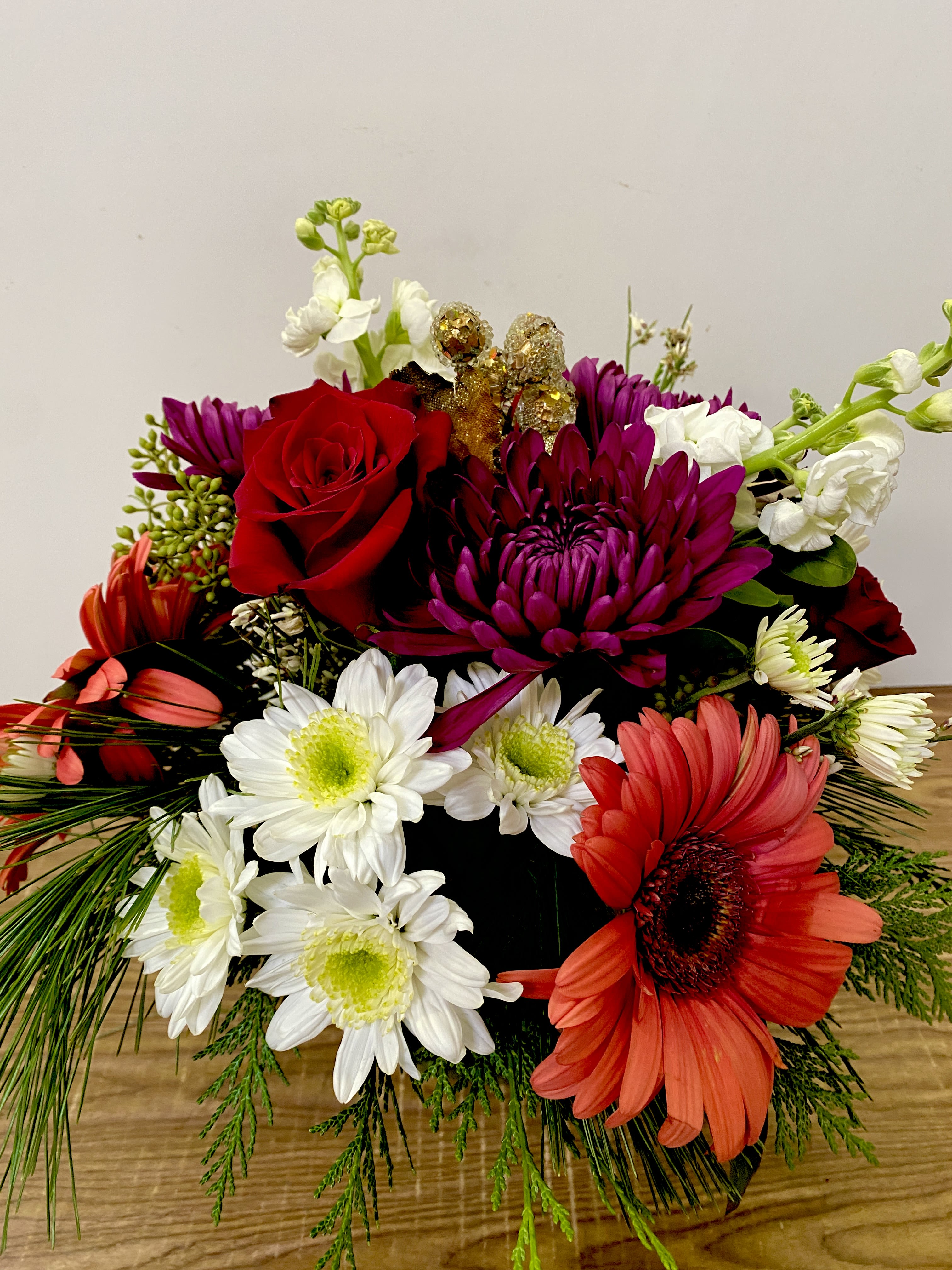 Santos coming - A Dramatic Statement from Your San Francisco Florist Celebrate with Santos Coming, an opulent arrangement designed to captivate and inspire. As a leading San Francisco Florist, Jane's Roses blends traditional elegance with contemporary flair to create artisanal pieces like no other. This design features a rich tapestry of deep crimsons and exotic textures, making it the perfect statement piece for modern home decor or high-end gifting.  Exotic Textures and Radiant Reds The Santos Coming arrangement is a masterclass in seasonal luxury, artfully combining:  Premium Red Roses: Velvety, deep-red blooms that offer a classic foundation of passion and elegance.  Sleek Red Tulips: Vibrant stems that add modern architectural height and crisp, clean lines to the design.  Bronze Cymbidium Orchids: Exotic focal points with chocolate-toned petals and intricate, speckled centers.  Cascading Amaranthus: Vibrant green tassels that mimic the movement of lush vines for organic texture.  Artfully Designed for Elegance Presented in a minimalist matte-white ceramic vessel, this compact yet impactful design ensures that the vibrant colors and unique textures take center stage. Trust your local San Francisco Florist for guaranteed quality, freshness, and unforgettable floral artistry.