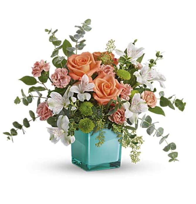 Sunset Splash Bouquet - Make a splash on any occasion with this wow bouquet! A fun-filled play on color, it contrasts pretty peach and white blooms with a watery aqua cube vase that's sure to become one of their year-round décor faves. This delightful arrangement features peach roses, white alstroemeria, peach miniature carnations, green button spray chrysanthemums, spiral eucalyptus, seeded eucalyptus, oregonia, and lemon leaf. Delivered in Teleflora's Aqua Color Splash Cube. Orientation: All-Around