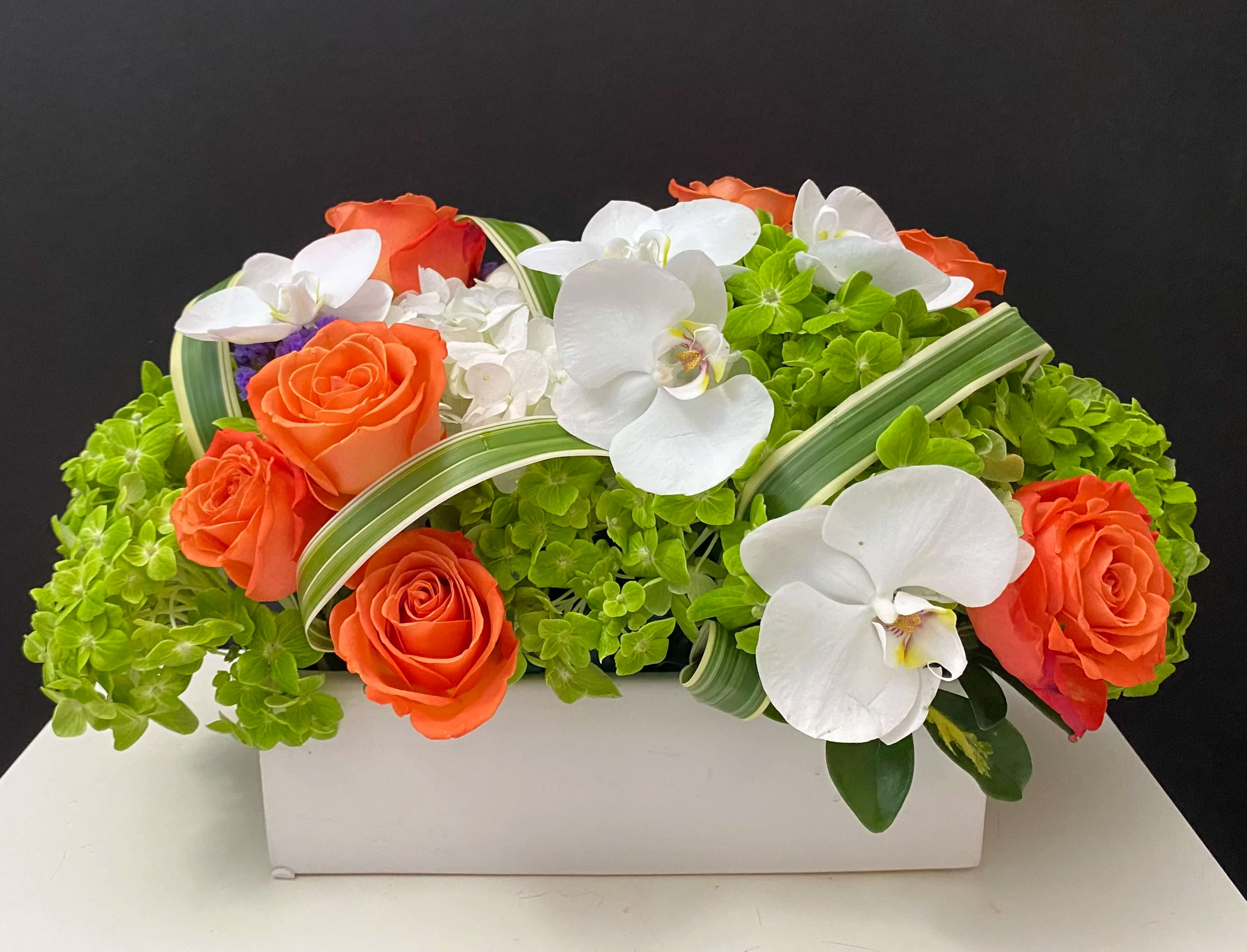 Flowers are ... - Roses, Hydrangeas, Orchid blooms in white ceramic container 