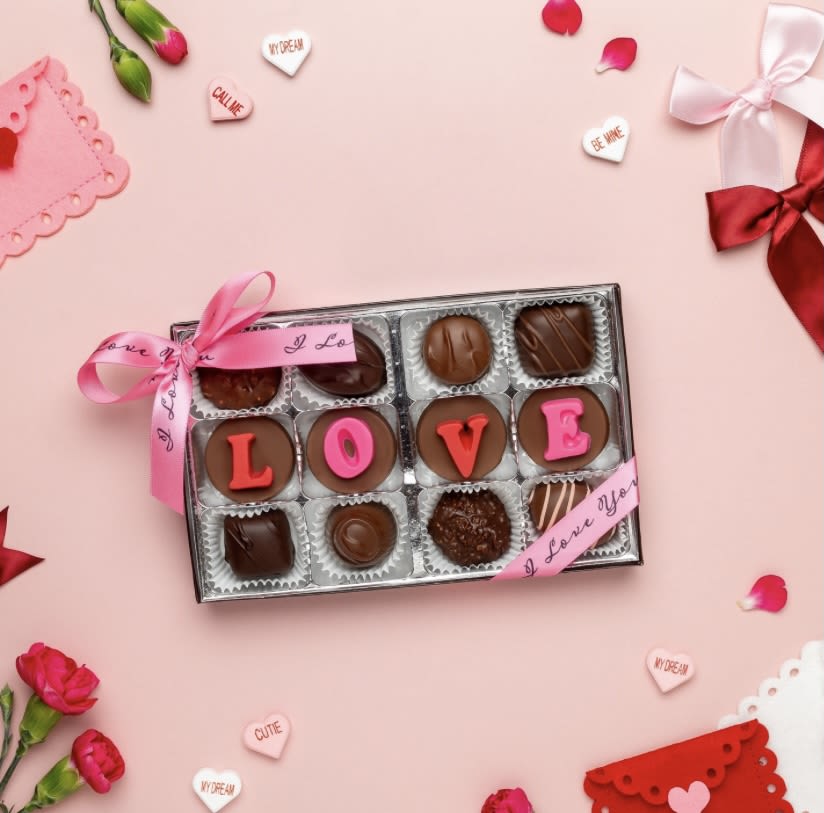 12 Piece Love Box - Enjou Chocolat of New Jersey  Indulge in a selection of Enjou's exquisite Connoisseur Collection lovingly presented in a bespoke box with a delicate bow. The middle row spells out "LOVE", on theme for Valentine's Day. A unique, hand-crafted gift option for your sweetie.  Box is 4 inches long and 7 inches wide. 