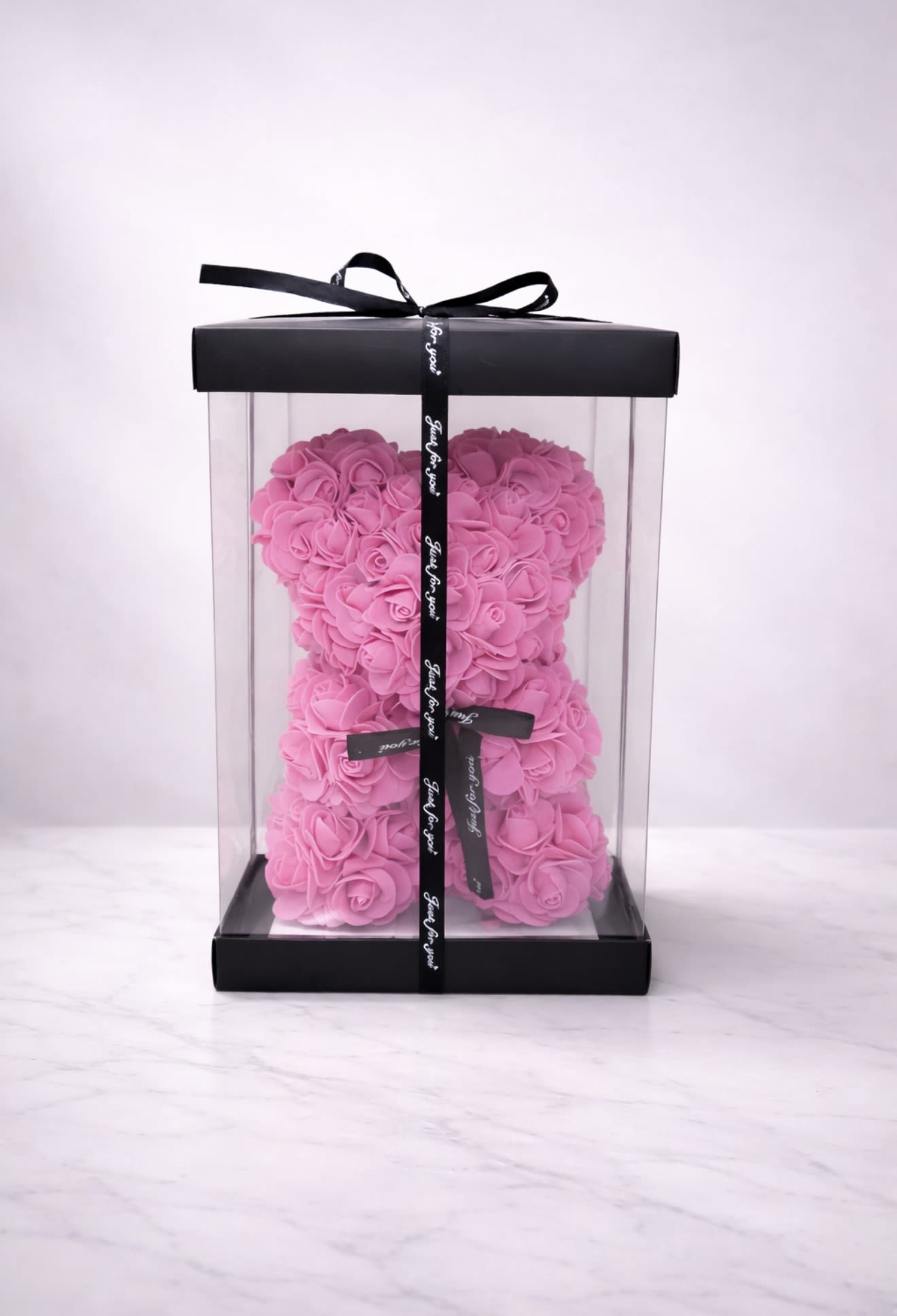 Blush Luxe Rose Bear - 10” luxury blush pink rose bear presented in a sleek acrylic display box with elegant black accents. This long-lasting keepsake is the perfect romantic gift for anniversaries, birthdays, and special occasions