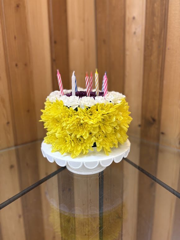 Birthday Cake Blossom  - Fresh Flower Birthday Cake Arrangement  Celebrate birthdays in the sweetest way—without the calories! Our Fresh Flower Birthday Cake Arrangement is a stunning floral creation designed to look like a birthday cake, beautifully arranged with fresh, vibrant flowers and presented on a classic white cake stand. Perfect for surprising a loved one, this unique arrangement is both eye-catching and unforgettable.  Handcrafted by the talented designers at Haehn Florist &amp; Greenhouses, this floral cake makes a memorable centerpiece for parties or a thoughtful delivery to someone special. Add a birthday balloon or card to make the gift even more personal.  Details:  Fresh seasonal blooms styled into the shape of a cake  Presented on a reusable white cake stand  Available in a variety of color palettes—cheerful brights, soft pastels, or elegant monochrome  Perfect for birthdays, office surprises, or as a centerpiece   Order Today from Haehn Florist &amp; Greenhouses  410 Hamilton Rd, Wapakoneta, OH 45895  419-738-8485  We offer same-day flower delivery in Wapakoneta, St. Marys, Lima, New Bremen, and surrounding areas. Send a gift that will be remembered long after the candles go out!