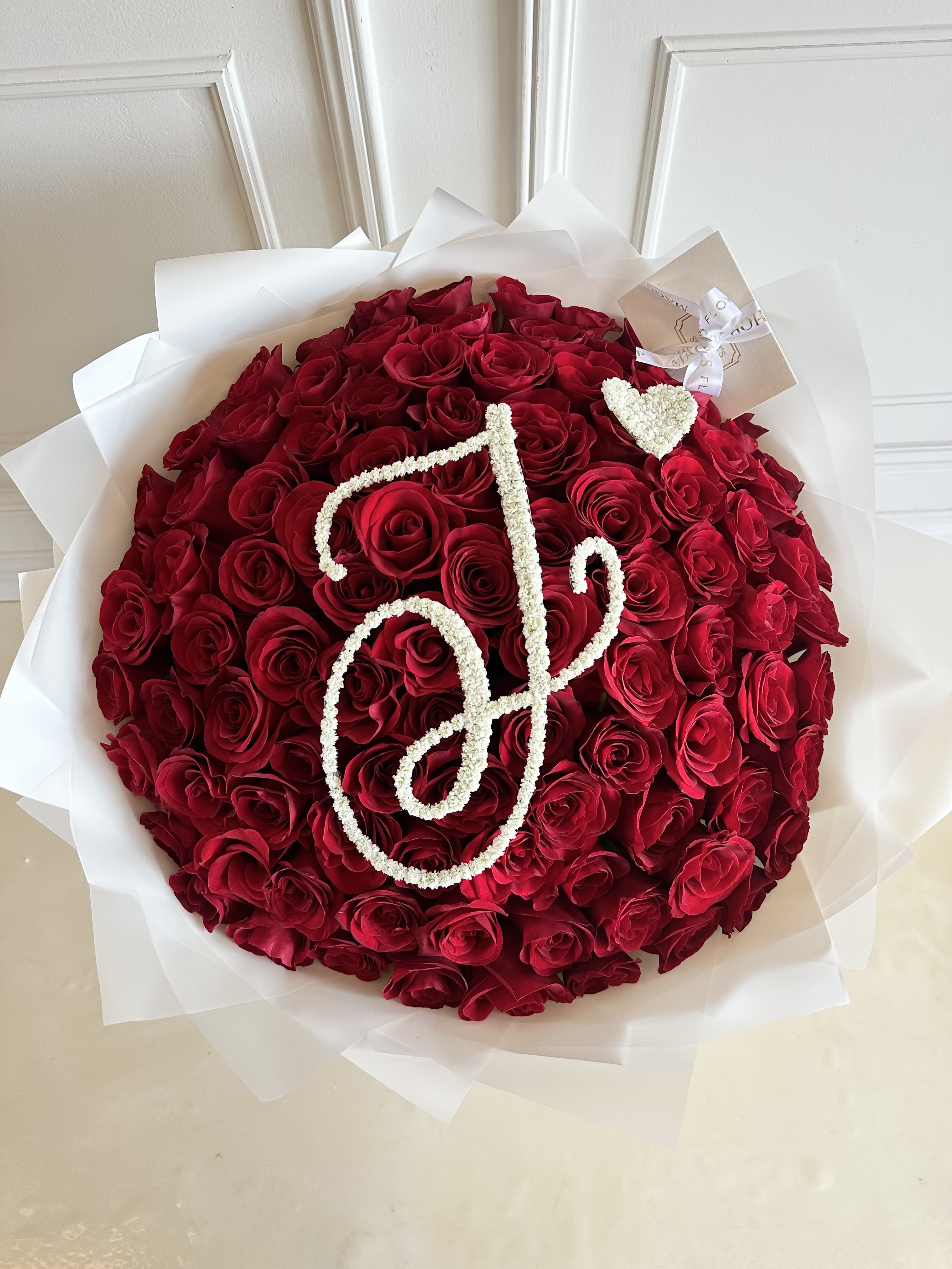 MFS 100 Rose Bouquet (Initial Design)  - 100 Red Rose Bouquet (Initial Design)   Under florist instructions/ special instructions please let us know what Letter you would like on the bouquet. Please note only 1 letter is allowed.   *This bouquet does not include a glass vase
