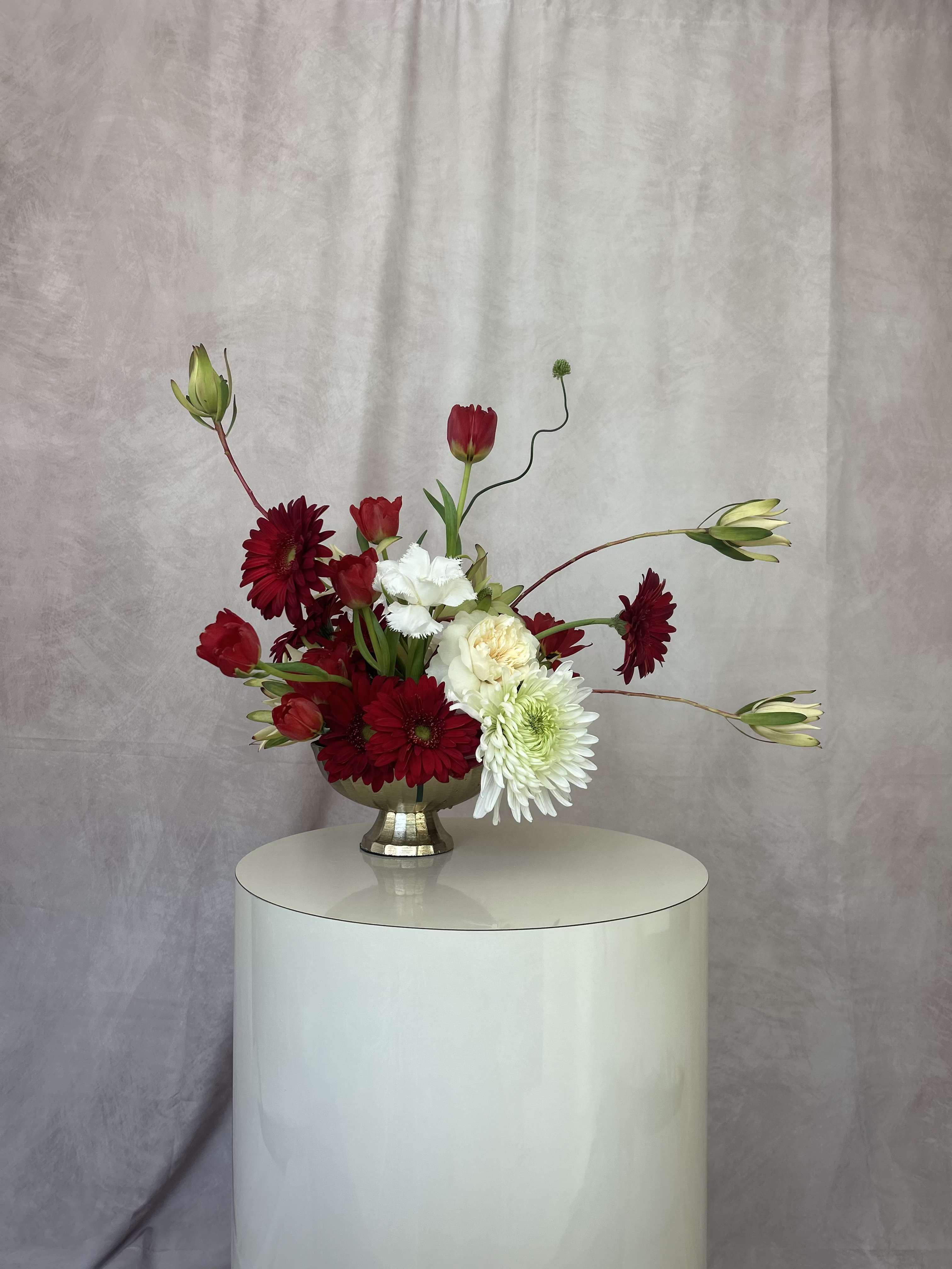 Moonlit Muse - Set in a gorgeous golden compote, a truly elegant combination of red roses and a variety of white and blush flowers. As with all our arrangements ~ we select the best, freshest and in season florals. This composition is a an inspiration, and what will be created for you is similar, but not exactly the same.  We do however promise that it will be equally as stunning as the composition in this image