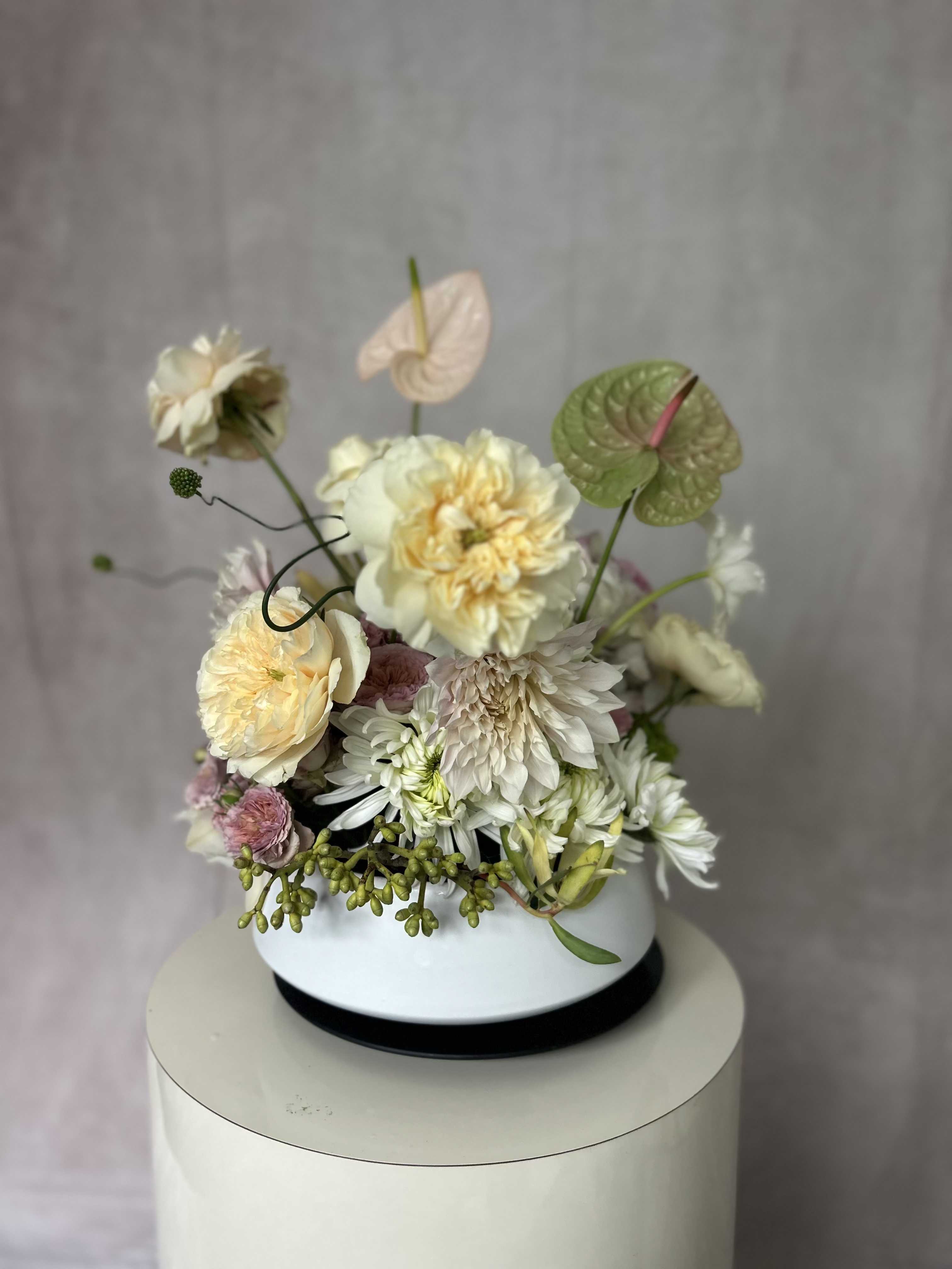 Blush Reverie - Set in a beautiful ceramic low and wide vessel, a majestic blush and peach composition of roses, dahlias, anthurium, hydrangeas. She is pure softness and delight, so easy on the eyes, playful and light  As with all our arrangements ~ we select the best, freshest and in season florals. This composition is a an inspiration, and what will be created for you is similar, but not exactly the same.  We do however promise that it will be equally as stunning as the composition in this image