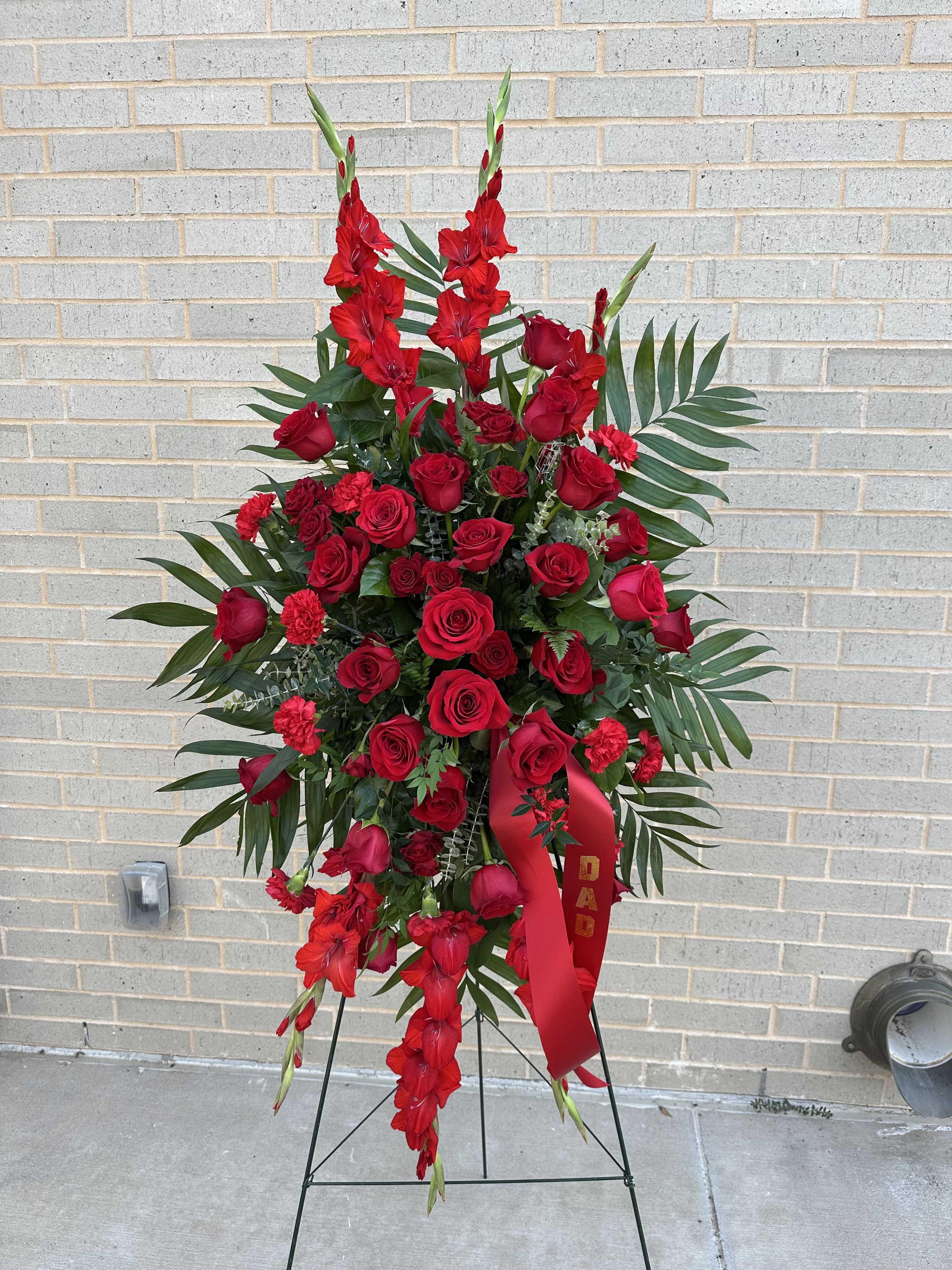 Red Consolation Easel - Standing easel will approximately match this -- flower substitutions may be needed Banner can be added for $10 (like image shows with "Dad" 