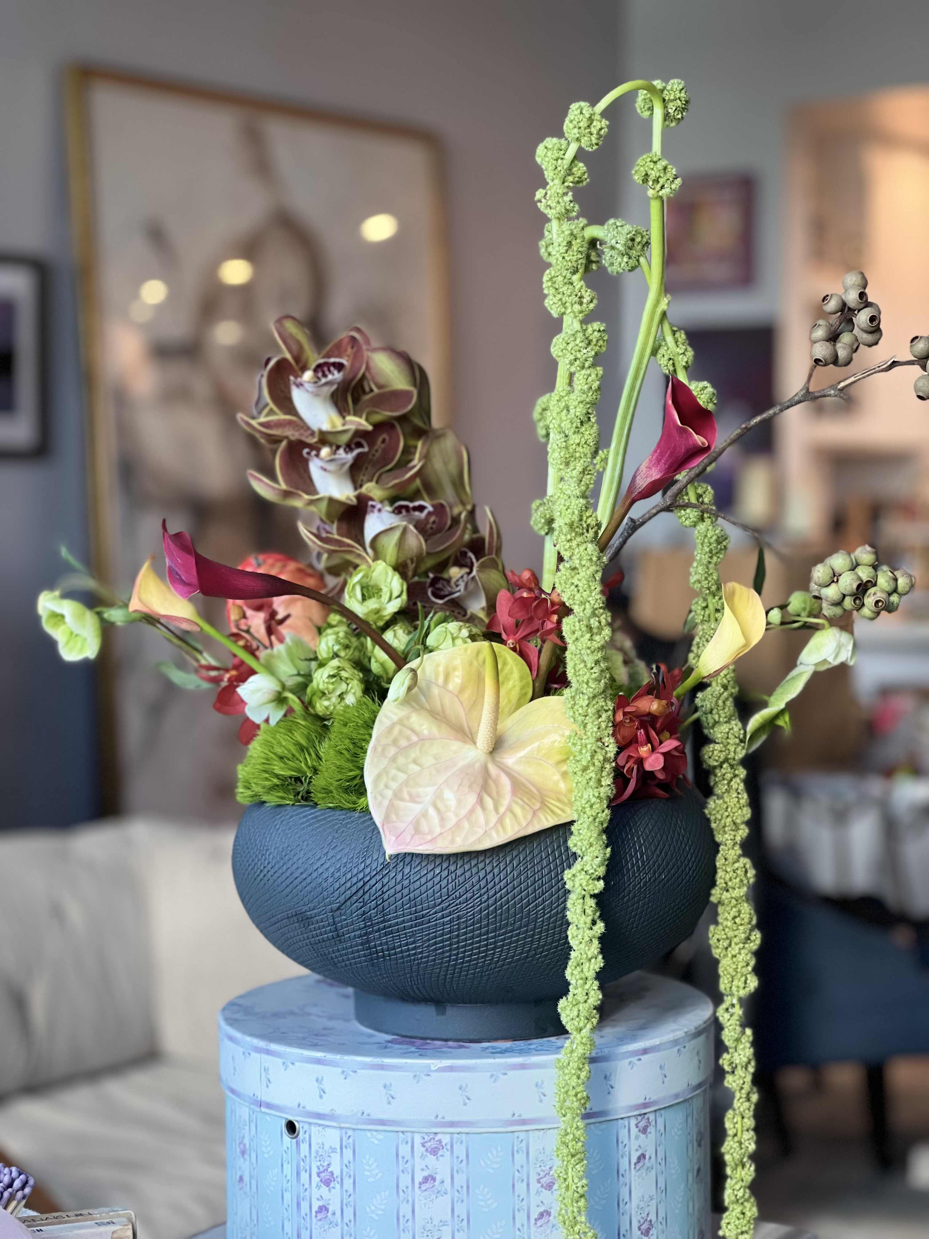 Celeste - In a beautiful extra large ceramic vessel, she resides ~ Cymbidium orchids, Anthuriums, Amranthus, Calla lillies, spry roses and so many more florals!  This arrangement is elegance and modern chic with a bit of tropical whisper 