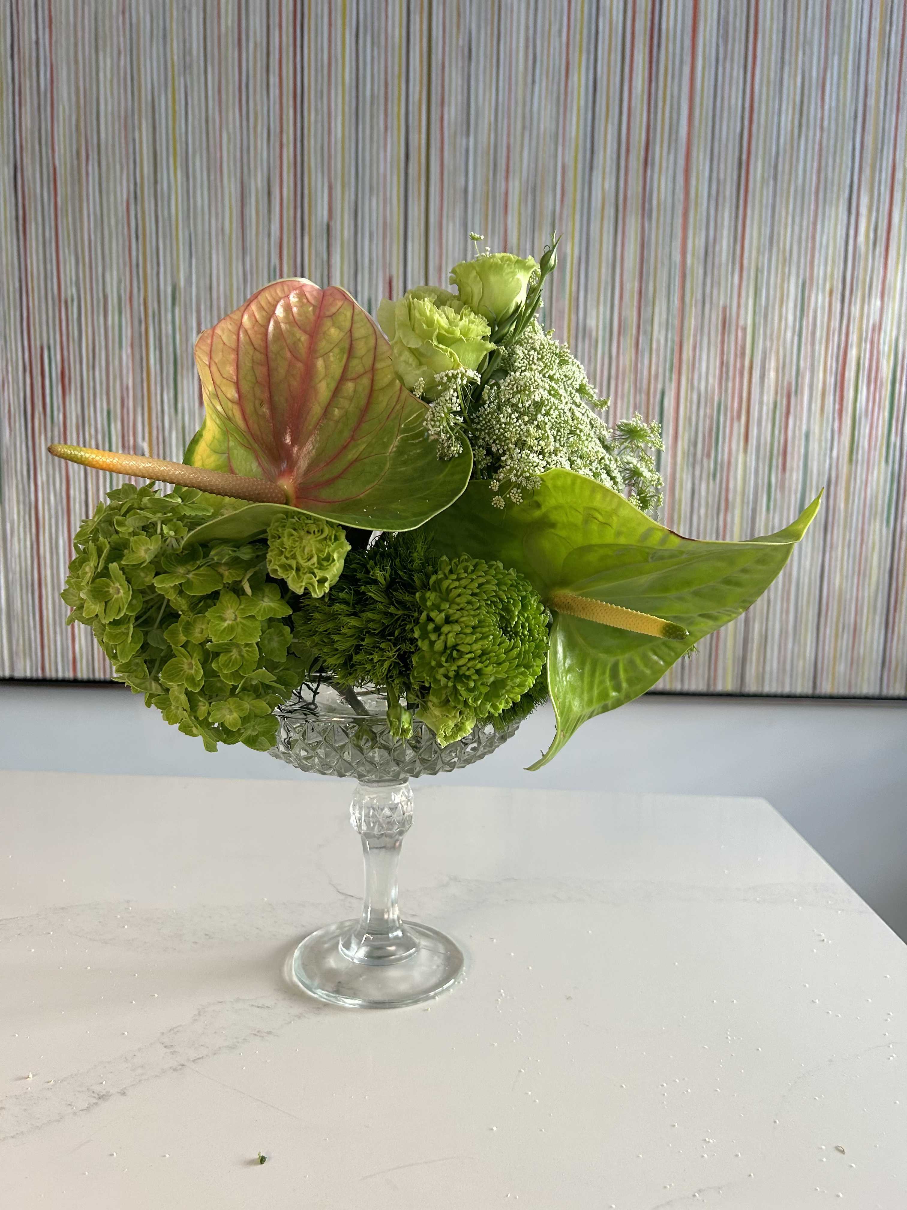Verde Princess - She is green and gorgeous ~ one tone arrangements are our specialty,  and green on green is certain to delight!  Especially when set in an amazing crystal vessel, and features anthuriums, hydrangeas and roses