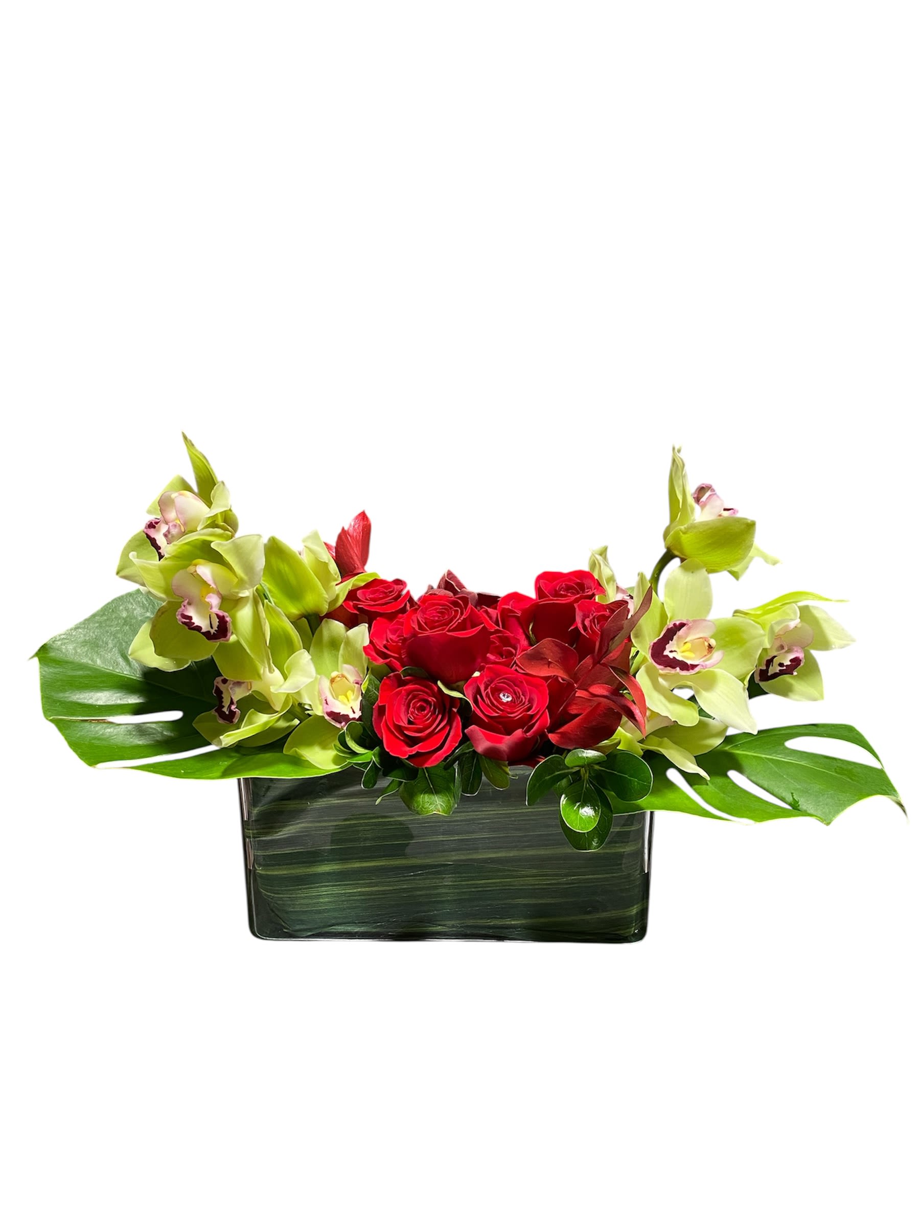 Red roses and green orchids in a rectangular glass vase