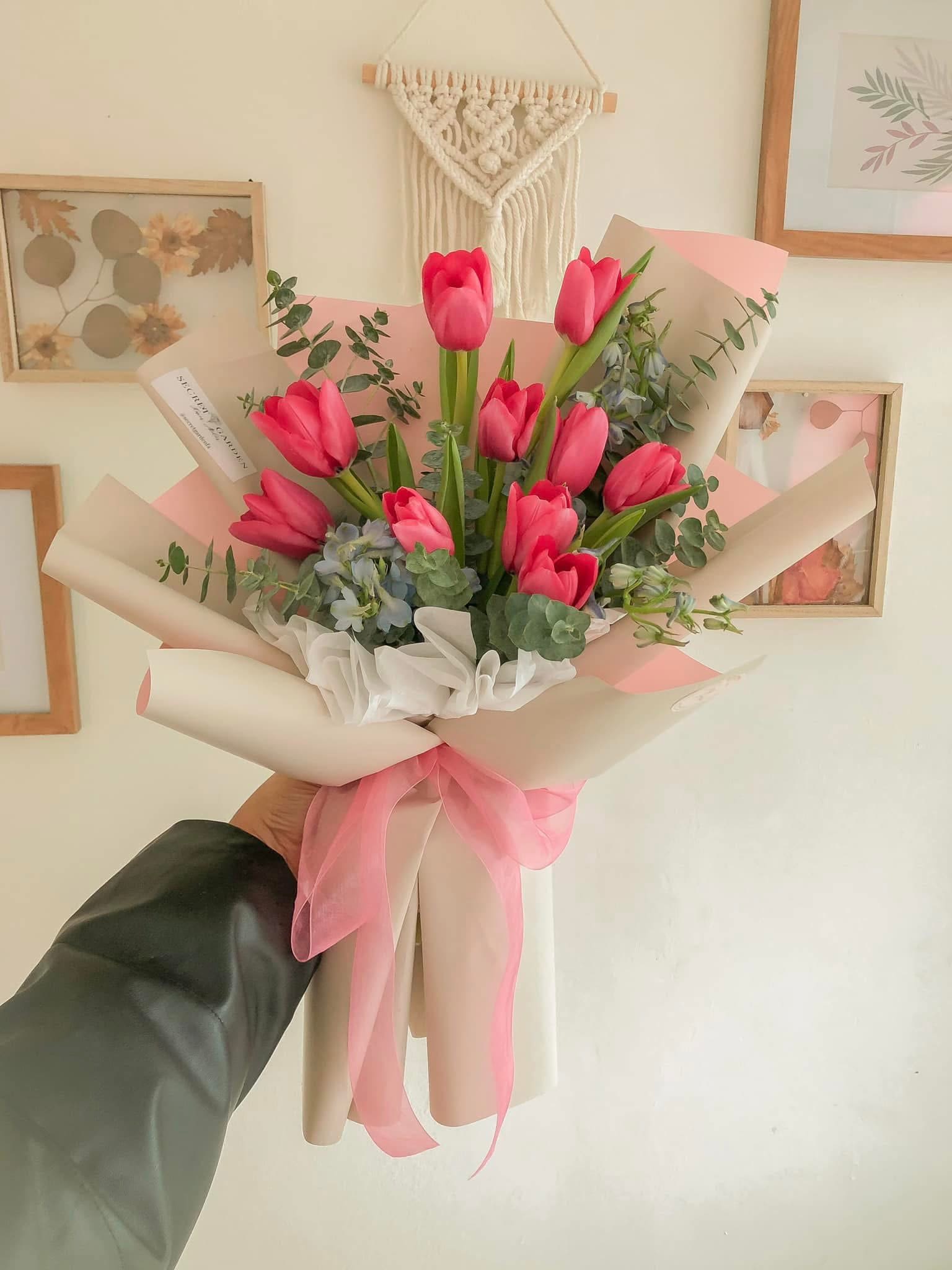 Pink tulip bouquet wrapped in cream paper with a pink ribbon