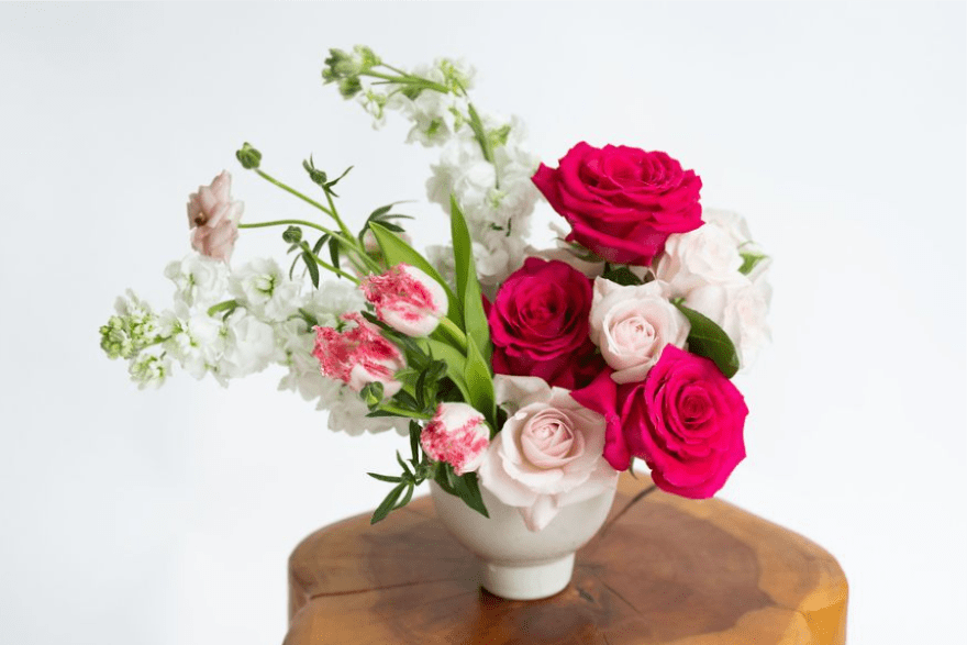 Rose Quartz - For when a dozen roses feels old hat, give your Valentine a fresh and modern take with this editorial-style design of hot pink roses and flashy frill tulips in a contemporary ceramic compote vase.  Oh là là!  Standard arrangement measures approximately 9" tall by 9" wide.