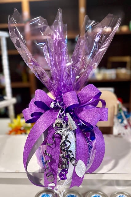 Game Day Spirit Bundle - Game Day Spirit Bundle is the perfect grab-and-go gift for any fan ready to cheer loud and proud. Wrapped beautifully in crisp cellophane and finished with a bold statement bow, this festive bundle is packed with fun game day treats and spirited touches that make it stand out at tailgates, watch parties, pep rallies, or surprise deliveries.  The best part? It’s fully customizable for any school or team. We can match school colors, add themed ribbon, incorporate team names, mascots, or even personalize it for a specific player, senior night, homecoming, or championship game.  Whether you’re celebrating a big win or sending a little sideline support, the Game Day Spirit Bundle brings the hype before kickoff even begins. 