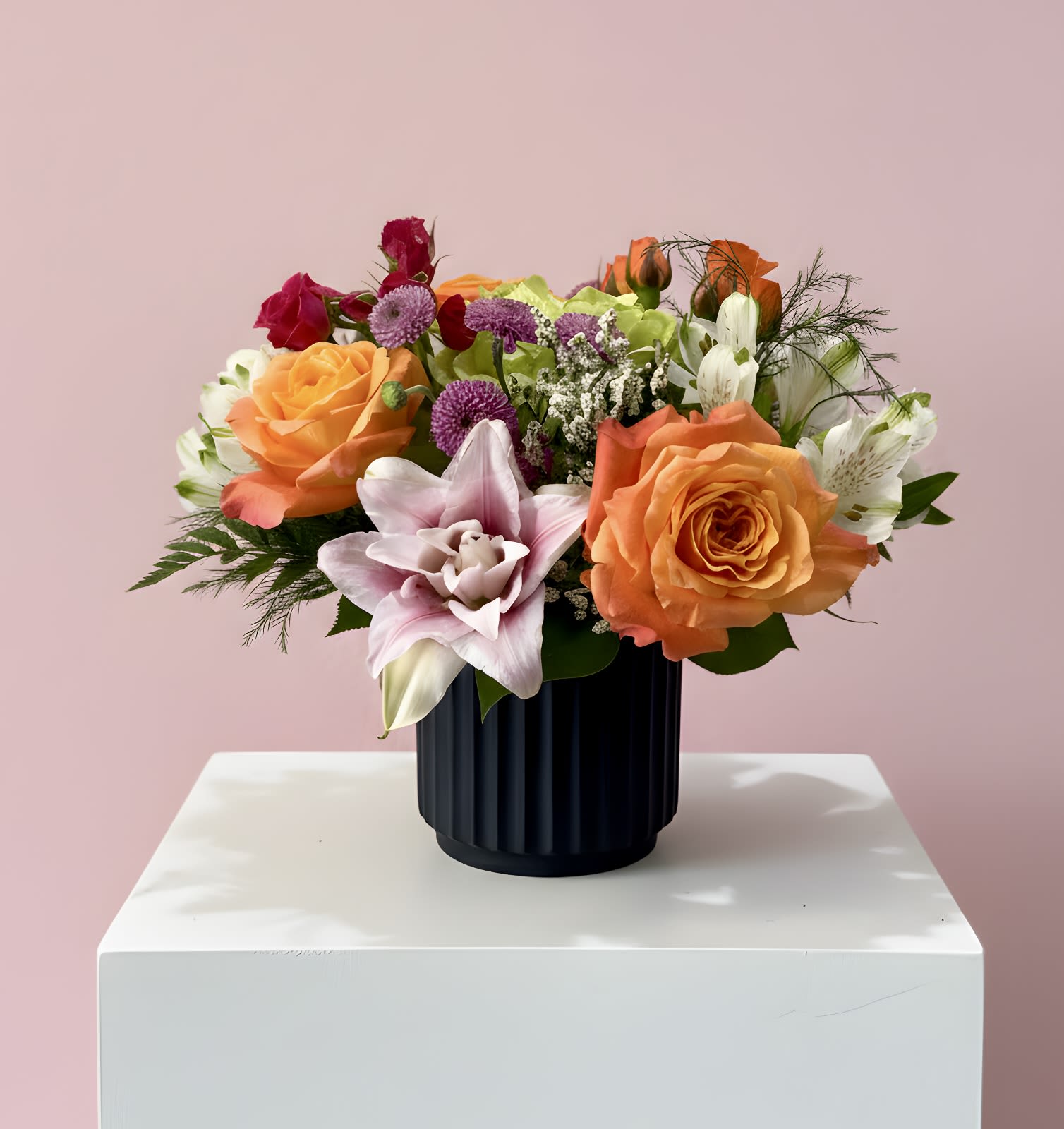 Spring After Dark  - A bold mix of vibrant pinks, juicy oranges, and fresh light greens designed in a sleek black vase for a modern, eye-catching look. Bright, playful, and effortlessly chic — where spring truly shines after dark.