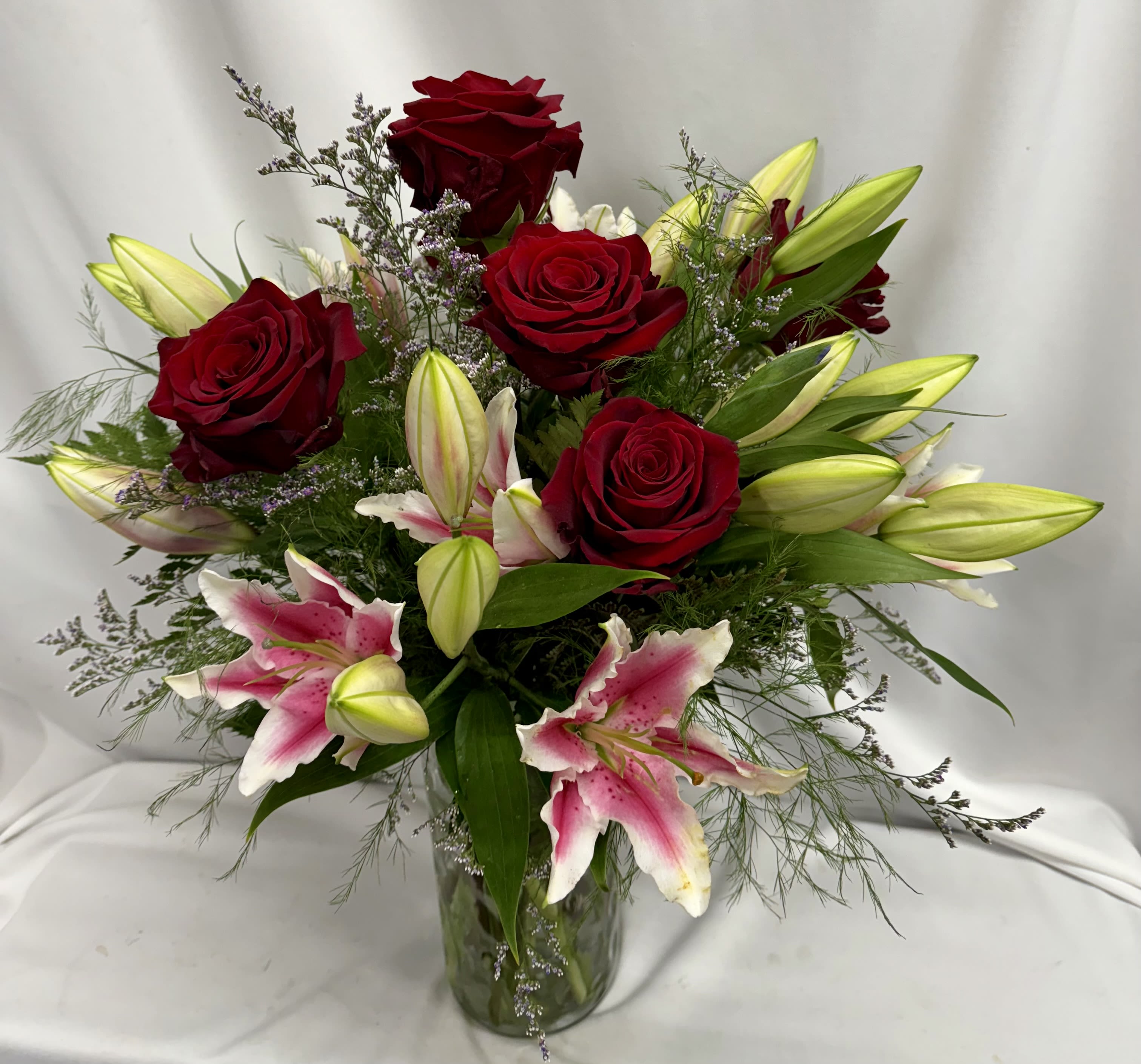 Star gazing  - This classic combo is perfect for any occasion. Fragrant  stargazer lilies, a half dozen of our premium red Explorer roses, arranged in a vase with assorted greens and filler. Please note when we get lilies in they are not fully open. Your arrangement will get more beautiful as the days pass when they start opening.