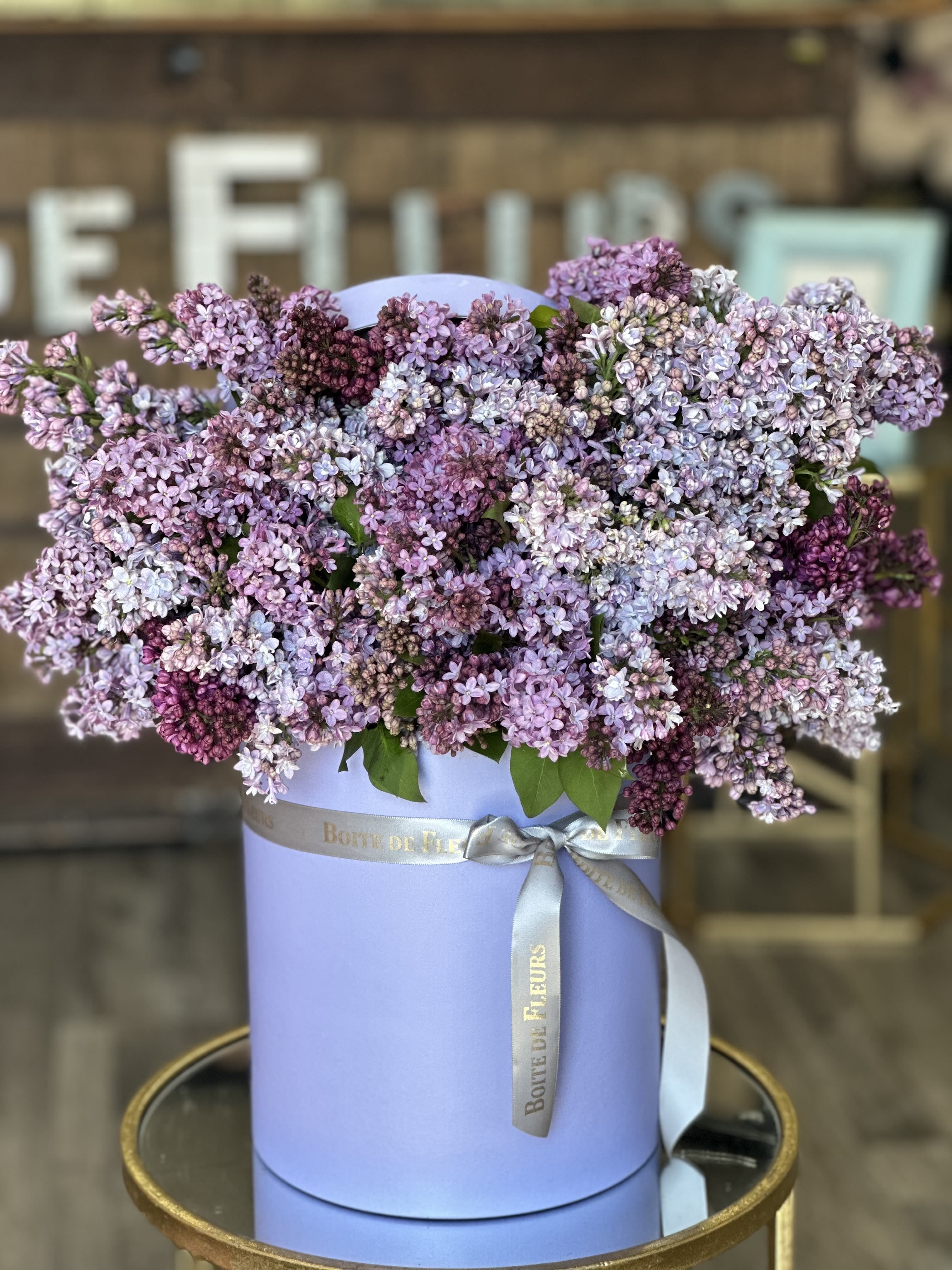 Lavender lilac bouquet in a round pastel box with a ribbon