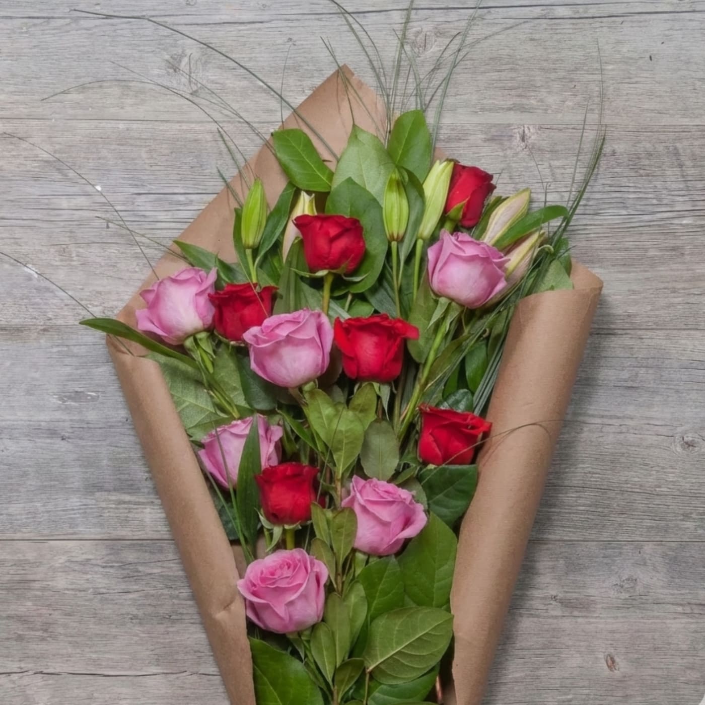 Bouquet of red and pink roses wrapped in brown paper