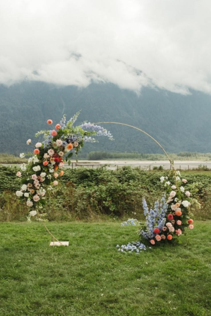 Flame &amp; Blossom Arch - Bold, radiant, and beautifully dynamic — Flame &amp; Blossom is a floral arch that ignites the senses with vibrant coral and pink blooms, gracefully intertwined with soft blue stocks. This striking combination balances warmth and coolness, creating a captivating display full of energy and elegance. Perfect for celebrations that call for a vivid statement, Flame &amp; Blossom transforms any space into a lively and enchanting setting — where passion meets delicate beauty in perfect harmony.