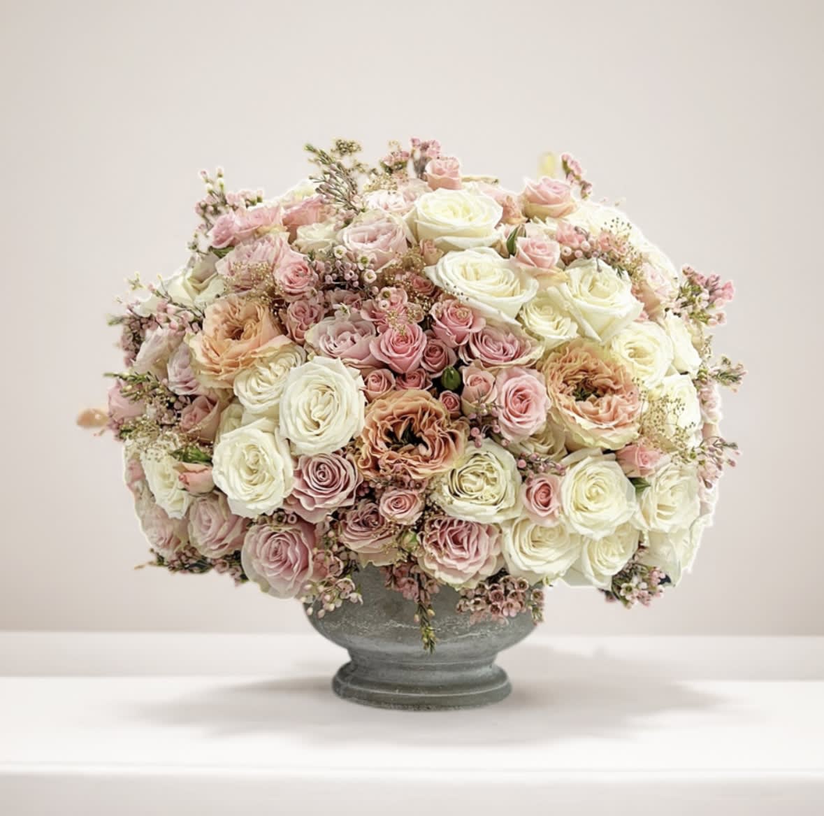 Blushing Symphony - Embrace tranquility with our captivating blush-colored roses nestled in a sleek cement vase. Each delicate bloom embodies elegance and grace, juxtaposed against the sturdy yet modern aesthetic of the vessel. Enhance your space with this harmonious blend of soft hues and contemporary design.