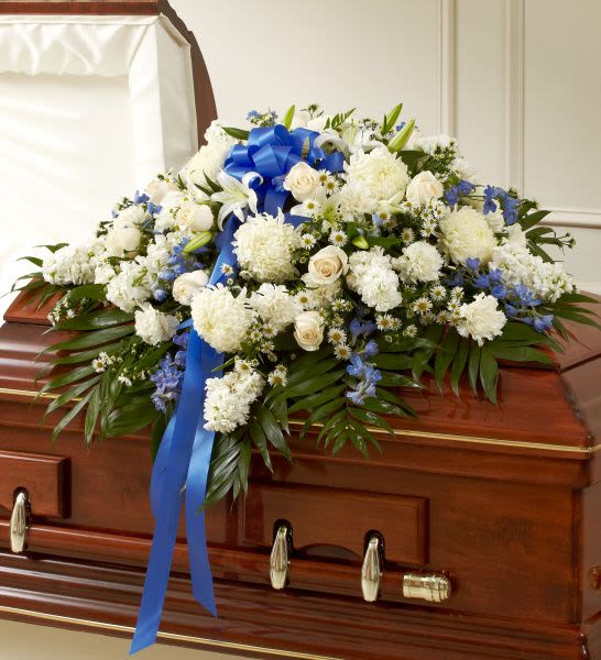 Rose Half Casket In Blue And White - Half casket arrangement of white roses, hybrid lilies, football mums, monte casino and stock, blue delphinium and emerald; accented with a blue satin ribbon