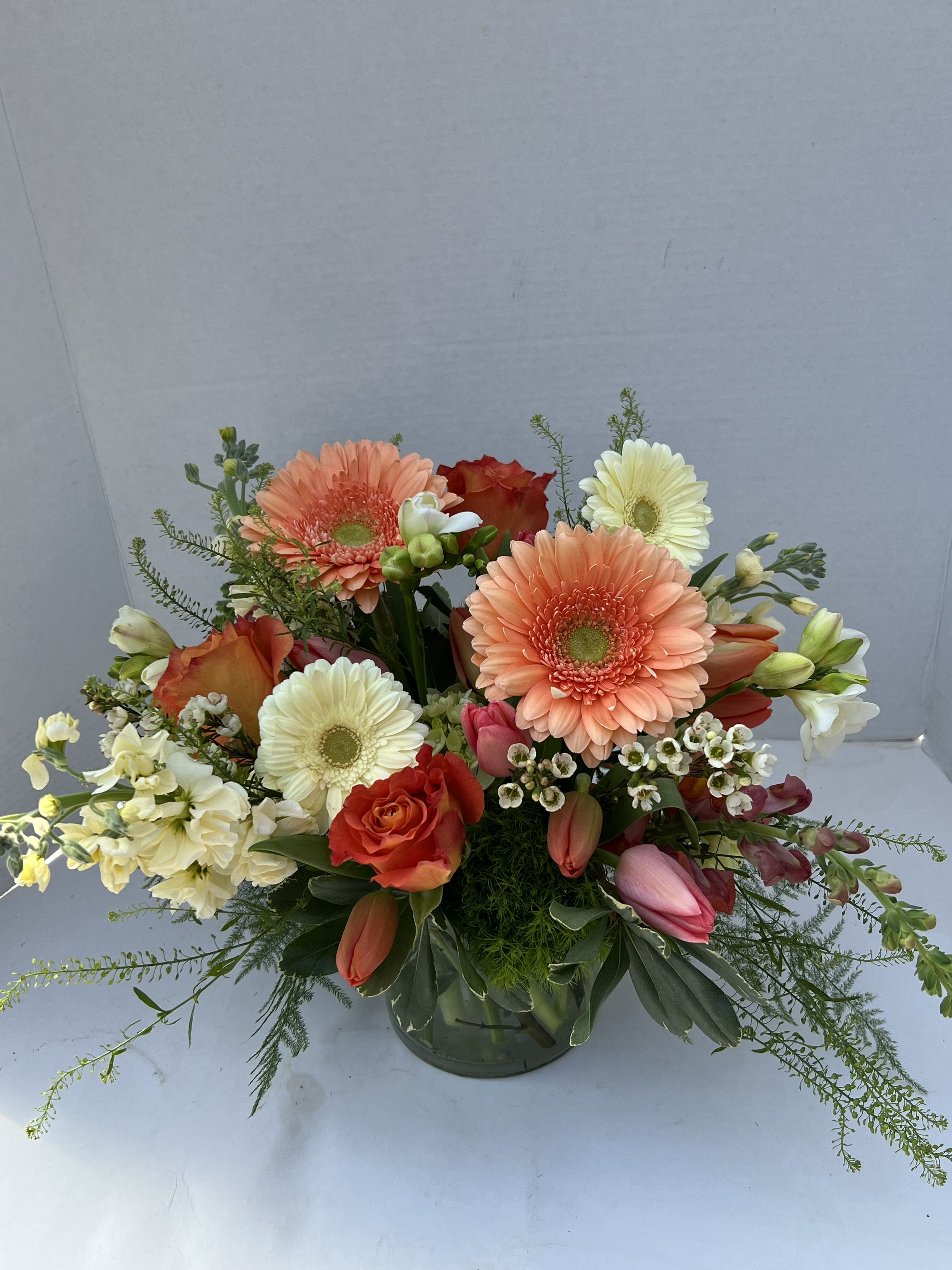 Creamsicle - Creamsicle is a joyful celebration of sunshine and sweetness, inspired by the nostalgic delight of an orange creamsicle on a warm afternoon. This radiant arrangement blends luscious peach gerberas with soft buttery yellows, creating a dreamy swirl of color that feels both refreshing and comforting. 