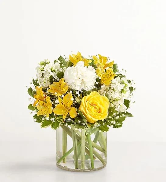 Yellow &amp; White Delight  - Full of sunny cheer, our brightly colored bouquet makes the kind of surprise that will leave them smiling. Yellow and white blooms are loosely gathered with lush greenery in a clear cylinder vase. Perfect for delivering warm sentiments to someone who means so much.