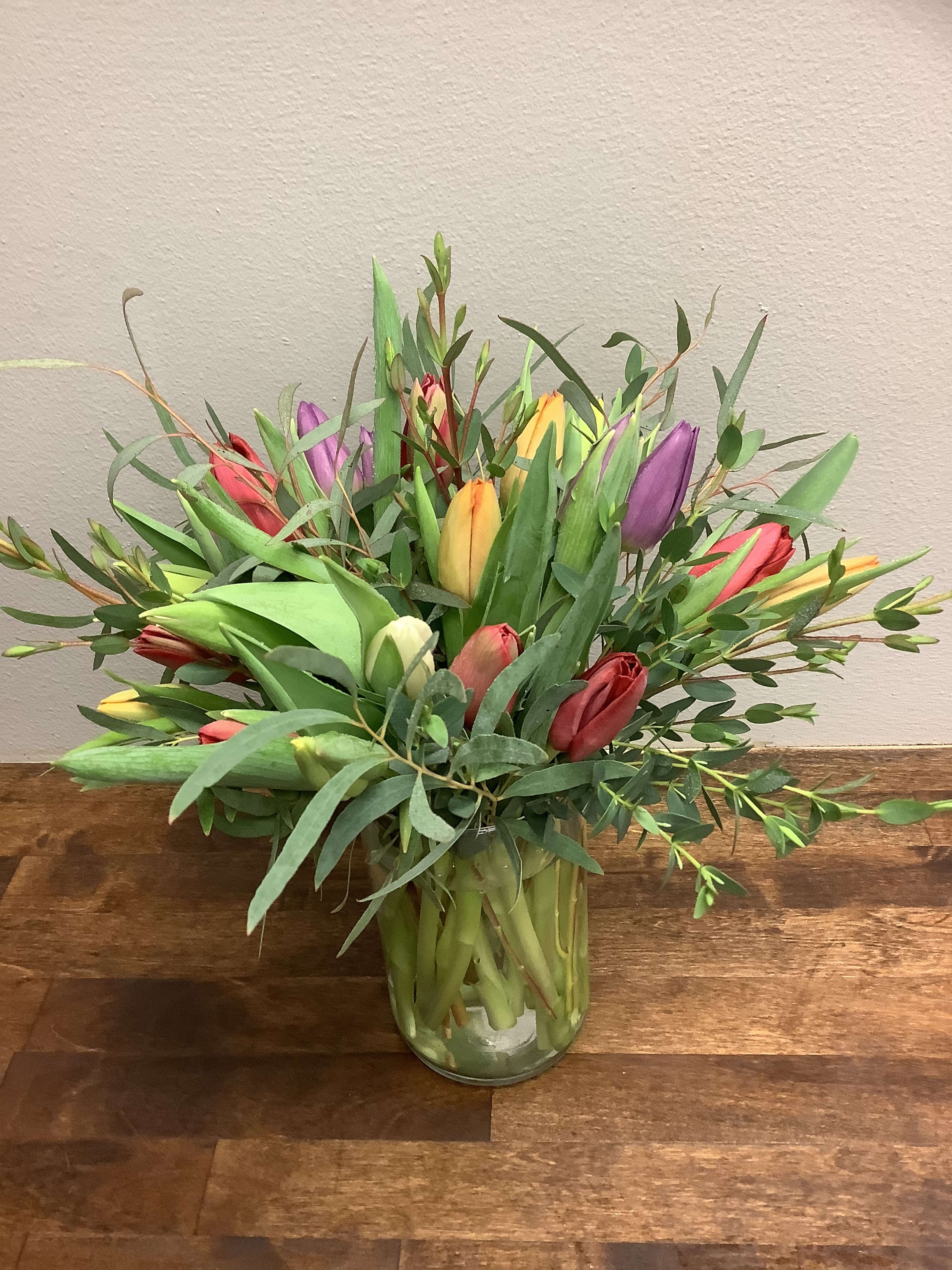 Tiptoe Thru  the Tulips - 2 dozen tulips (or more!) - 24 assorted tulips herald the arrival of the season, beautifully designed in a lovely vase. The fullness of the high quality tulips needs no additional frills. Color assortment will vary, and will include at least 3 colors of tulips. For additional colors and even more blooms, check out the Deluxe (36 tulips) and Premium (50 tulips!) upgrades. Vase may vary from what is pictured.