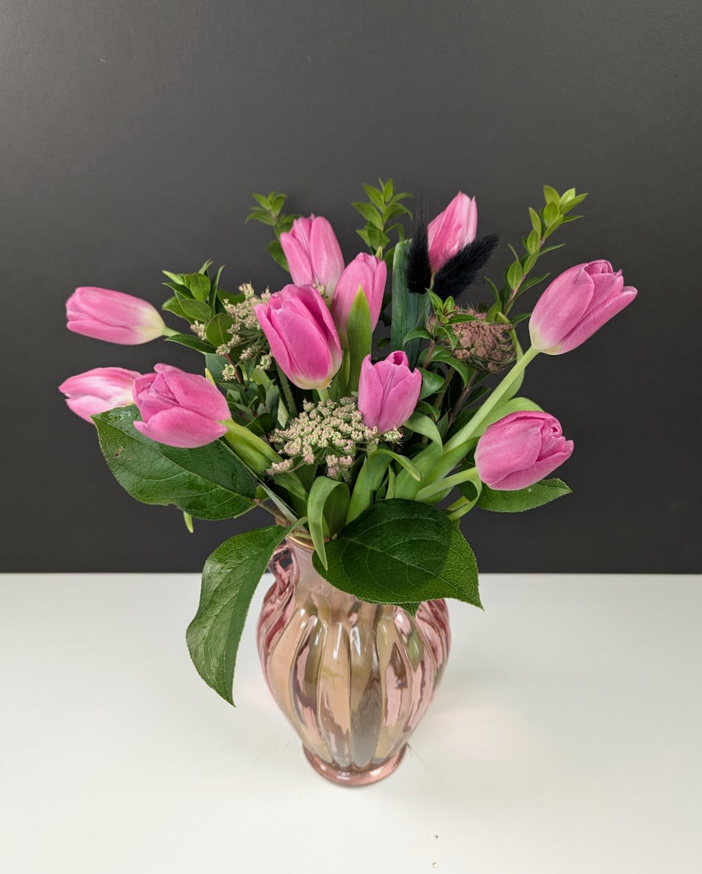 Pink Tulip Dream - Pink Tulip Dream – A delicate symphony of soft pink tulips arranged in a matching pink vase, radiating charm and elegance. This arrangement captures the beauty of spring with its graceful tulip blooms, making it the perfect gift for a loved one or a dreamy addition to any space. Simple, sophisticated, and effortlessly beautiful.