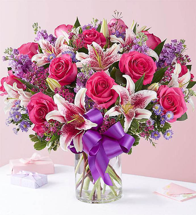Straight from the Heart™ Bouquet - A gift means so much more when it’s straight from the heart. Our stunning Valentine’s bouquet of passionate pinks and purples is expertly arranged in our chic cylinder vase and wrapped in a purple satin ribbon for the perfect finishing touch. It’s a romantic surprise that speaks volumes about the love you feel.  All-around arrangement of hot pink roses, pink Stargazer lilies, lavender stock, purple waxflower and monte casino, and assorted greenery  To ensure lasting beauty, lilies may arrive in bud form, and will fully bloom over the next few days  Premium arrangement measures approximately 22"H x 18"L Deluxe arrangement measures approximately 20"H x 18"L Regular arrangement measures approximately 18"H x 15"L  Artistically designed in a clear glass cylinder vase accented with a purple satin ribbon; measures 8"H  Our florists select the freshest flowers available, so colors and varieties may vary due to local availability  