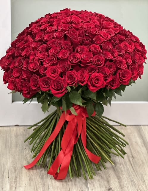  50 Red Rose Bouquet - A modern take on a classic red rose bouquet, with fresh-cut roses, exposed stems and leaves, finished with an elegant satin ribbon.    Available Sizes:  Deluxe: 100 stems Premium:150 stems     Some florals are seasonal, if a particular flower will not be available due to season, we will substitute for similar flower, composition, color pallet and value of the arrangements as closely as possible. All effort to create a floral arrangement as close to the photo shown, the actual arrangement may vary slightly in its appearance from the photo shown. If you have any questions about your order, we welcome you to call us in or email    Holiday Delivery:  Same-day delivery available. Deliveries are made throughout the day based on routing.  