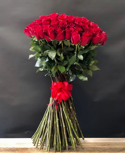25 Red Rose Bouquet   - A sleek, modern bouquet of 25 fresh cut crimson red roses with exposed stems, lush leaves. Designed for a clean, contemporary look. Each bloom is carefully selected and finished with a matching elegant satin ribbon.   Available Sizes:  Deluxe: 50 stems Premium:100 stems      Some florals are seasonal, if a particular flower will not be available due to season, we will substitute for similar flower, composition, color pallet and value of the arrangements as closely as possible. All effort to create a floral arrangement as close to the photo shown, the actual arrangement may vary slightly in its appearance from the photo shown. If you have any questions about your order, we welcome you to call us in or email    Holiday Delivery:  Same-day delivery available. Deliveries are made throughout the day based on routing.