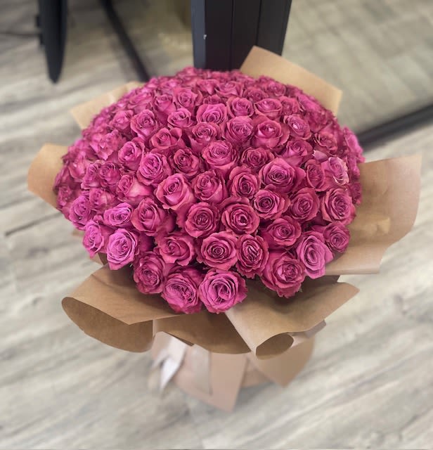 50 Fuchsia Rose Bouquet  - A vibrant bouquet of 50 fuchsia fresh cut roses with exposed stems and lush leaves creating a modern and elegant presentation. Bouquet finished with matching satin ribbon.    Premium wrapping is available for an additional $10. Please add in the order instructions if you would like this upgrade. Available Sizes:   Deluxe: 100 stems Premium:150 stems      Some florals are seasonal, if a particular flower will not be available due to season, we will substitute for similar flower, composition, color pallet and value of the arrangements as closely as possible. All effort to create a floral arrangement as close to the photo shown, the actual arrangement may vary slightly in its appearance from the photo shown. If you have any questions about your order, we welcome you to call us in or email    Holiday Delivery:  Same-day delivery available. Deliveries are made throughout the day based on routing.          