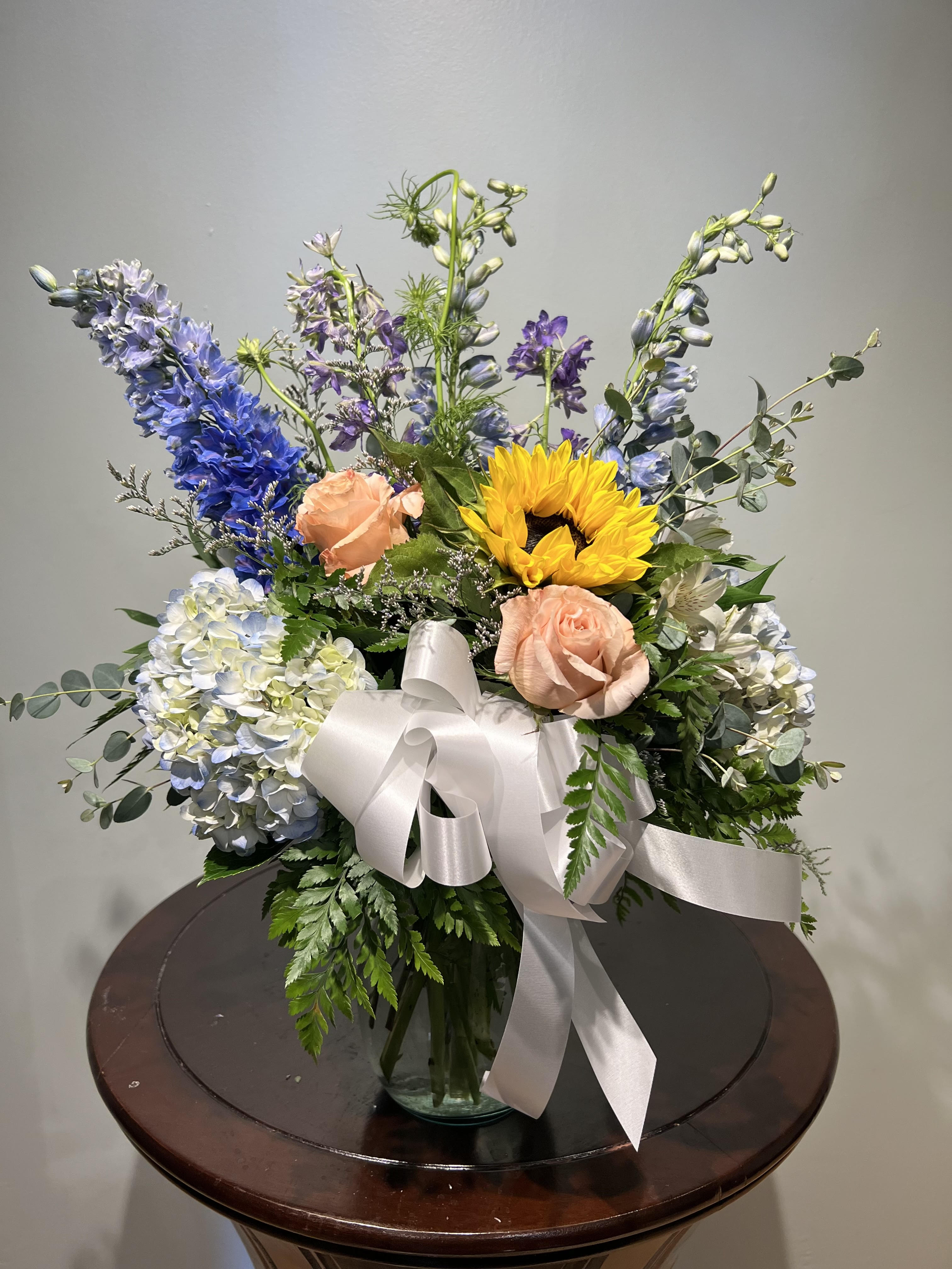 When A Man Loves A Woman - Want something a little different this valentines day to show her how one of a kind she is? Does she like the color blue and peach colored roses? Does she like to be unique? Look no further then this gorgeous arrangement. Flowers may vary depending on floral availability.  