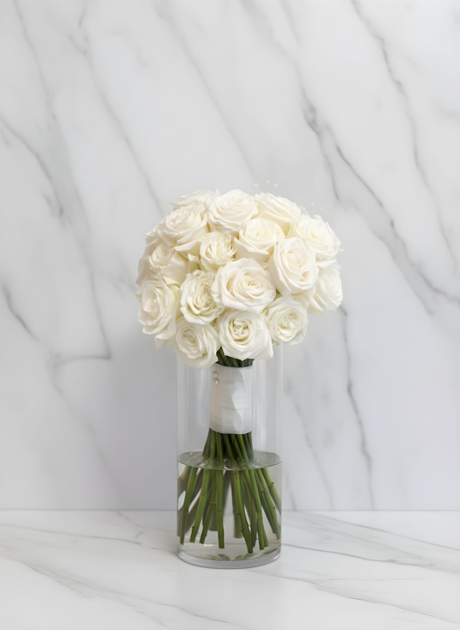 The Bridal Cloud - Graceful, timeless, and beautifully refined, this elegant bridesmaid bouquet features fresh white roses arranged in a perfectly rounded hand tied design. Agraciado, atemporal y bellamente refinado, este elegante ramo de dama de honor presenta rosas blancas frescas puestas en un diseño perfectamente redondeado y atado a mano.