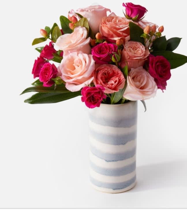 Lovely - A fun mix of 1 dozen, vibrant colored hot pink and coral/orange roses and spray roses, created in a more compact design, using a unique vase. Container may vary. 