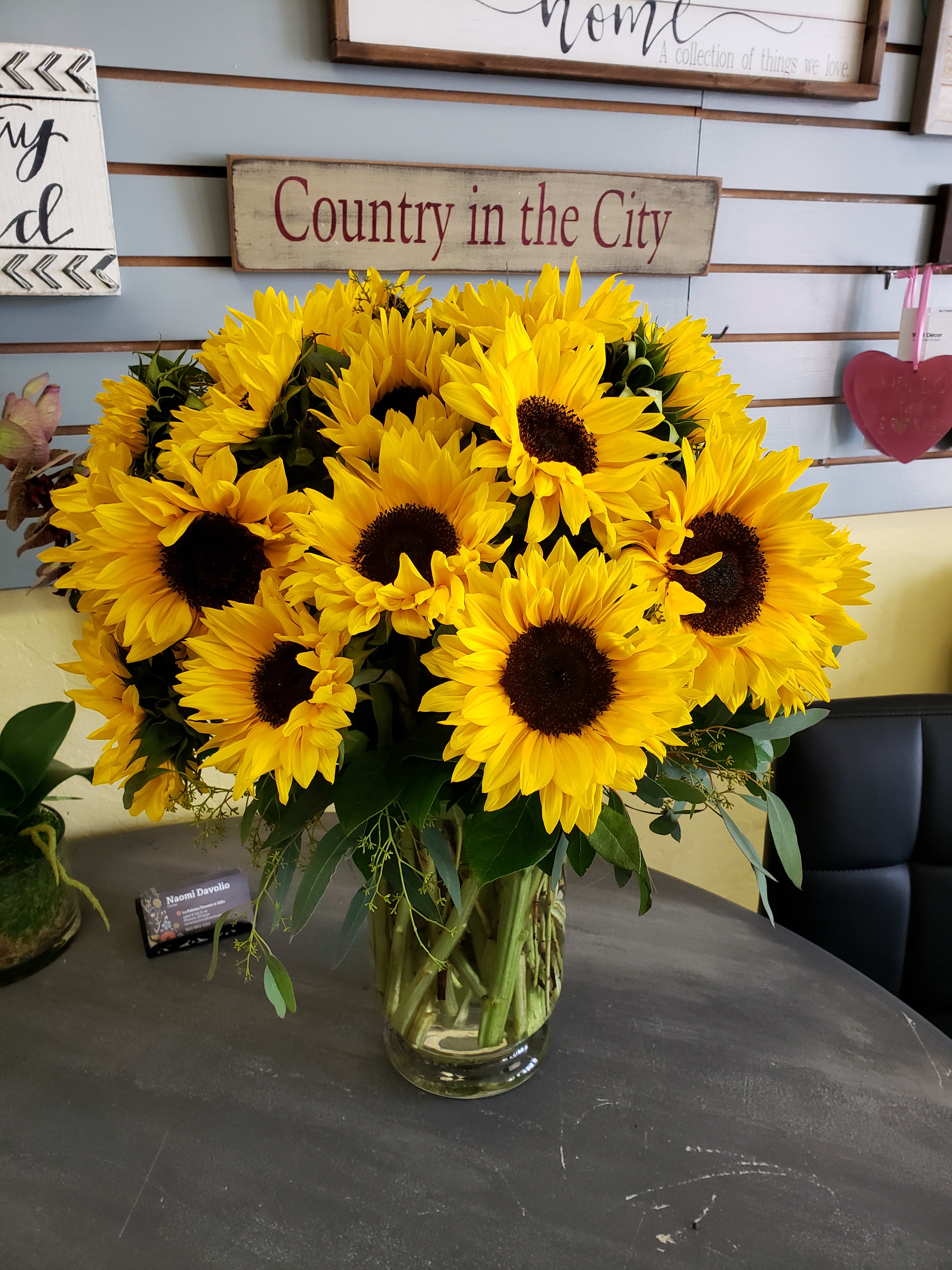 Oh Happy days! - Stunning Sunflowers arranged in a clean design with lush greenery and seeded eucalyptus. Premium version pictured.  Photo shown is Premium Version