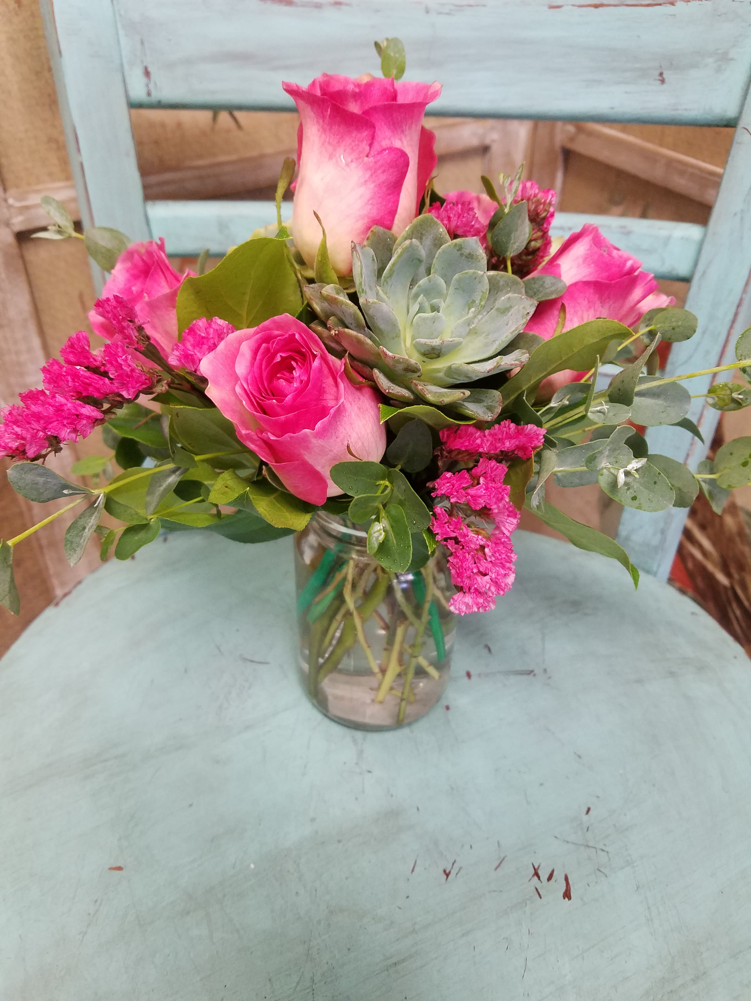 Pink Fusion - This unique arrangement designed with succulents, hot pink roses and pink statice will bring a smile to any woman.