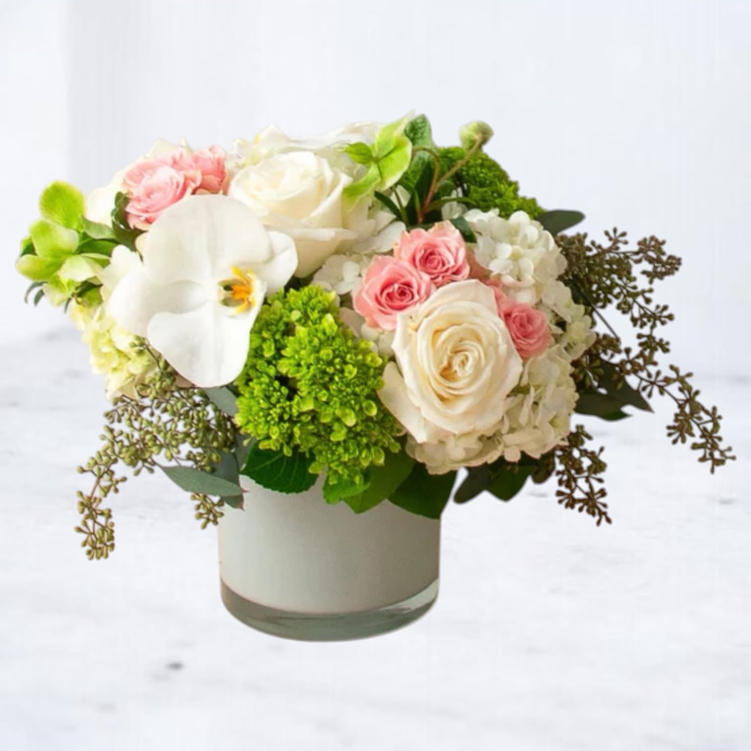 Ethereal Charm - Delicate and captivating, the Ethereal Charm is a harmonious blend of soft pink roses, creamy white orchids, and lush green accents. This beautiful arrangement, presented in an elegant vase, radiates sophistication and grace. Perfect for expressing love, celebrating milestones, or offering comfort, these blooms embody tranquility and refined beauty. Make any moment unforgettable with this serene floral masterpiece.