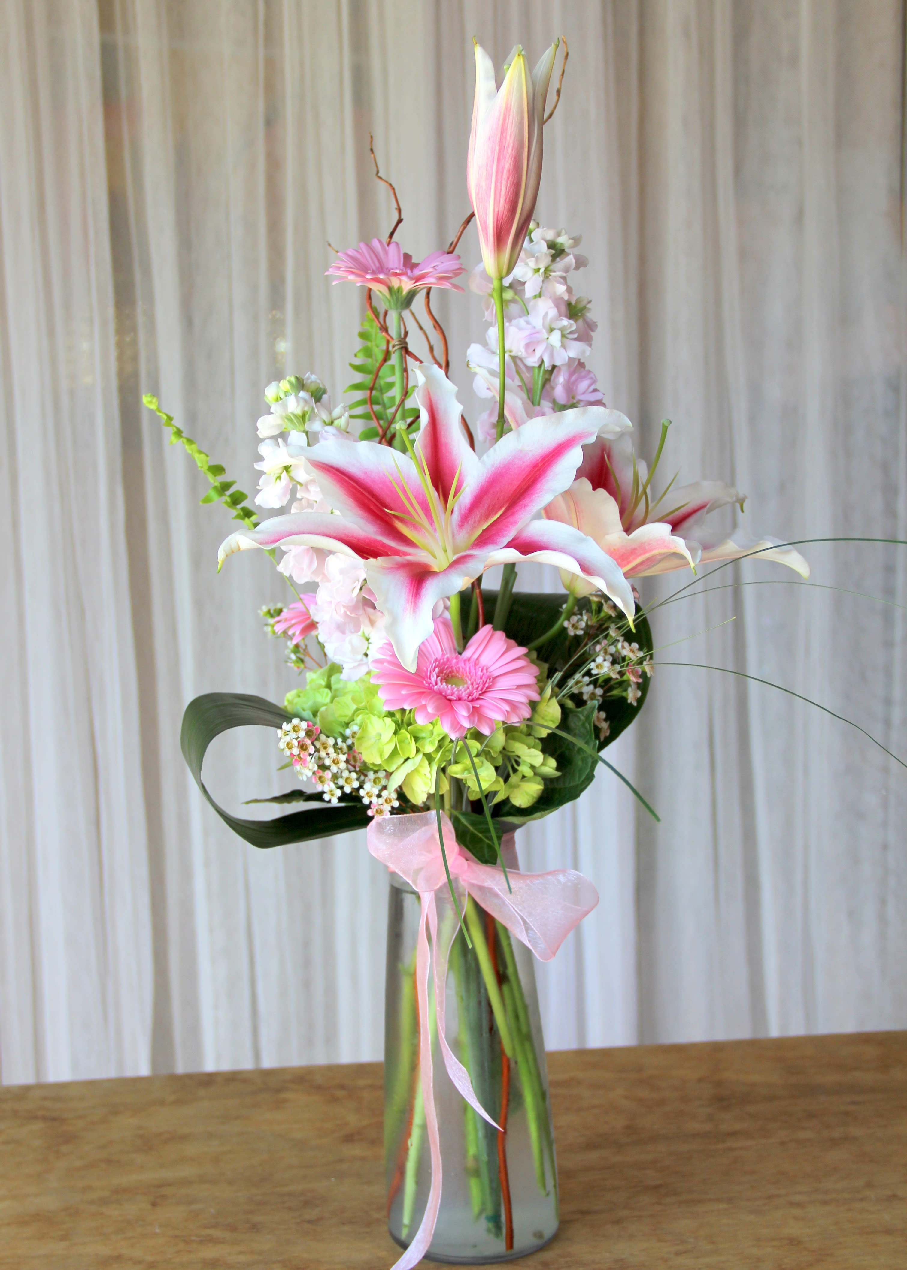 Pink Elegance - With this touch of elegance that anyone would enjoy, the fragrance of these flowers will fill a room with love. colorful stock, stargazer lilies, gerbera daisies, green hydrangea....colors may vary