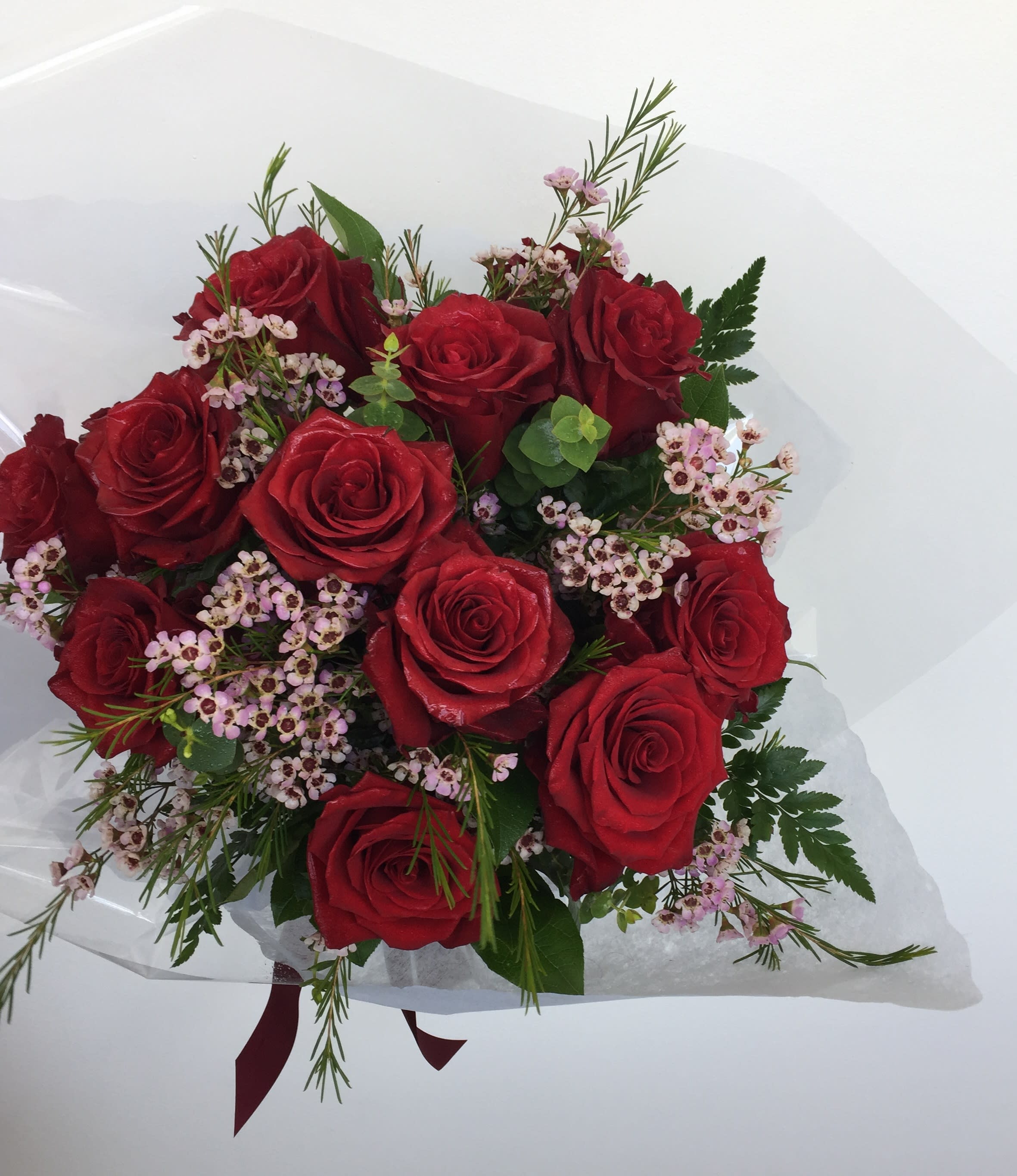 A Dozen Wrapped Roses - Twelve long stemmed roses in your choice of color with the works. Please indicate your color choice in special instructions.  *Premium selection gets 6 more roses