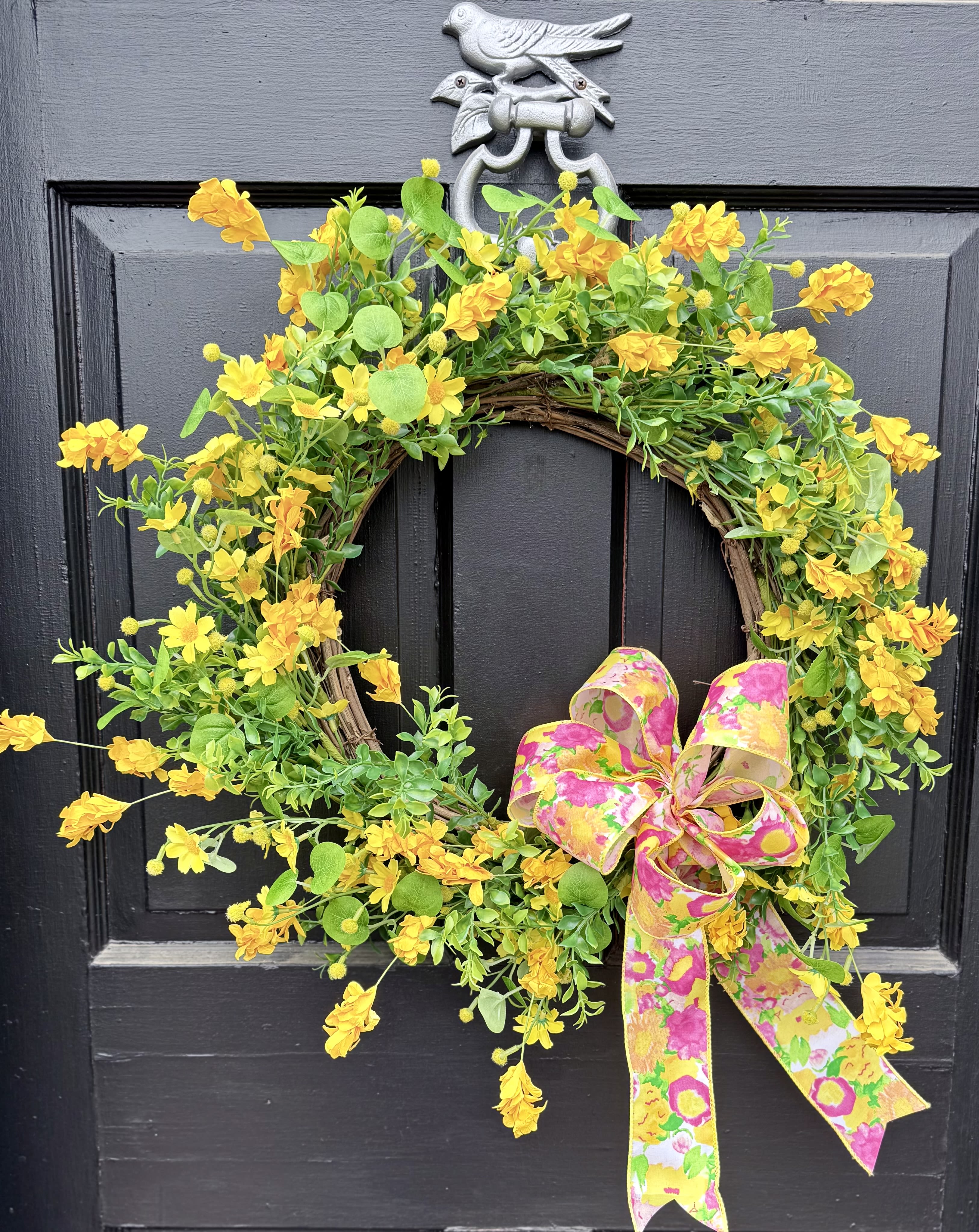 Spring Sunshine Wreath  - A 22” wreath in bright sunny yellow with a bright spring bow. Made of all artificial flowers to withstand outdoor elements. Perfect for the front door or anywhere in the home. 
