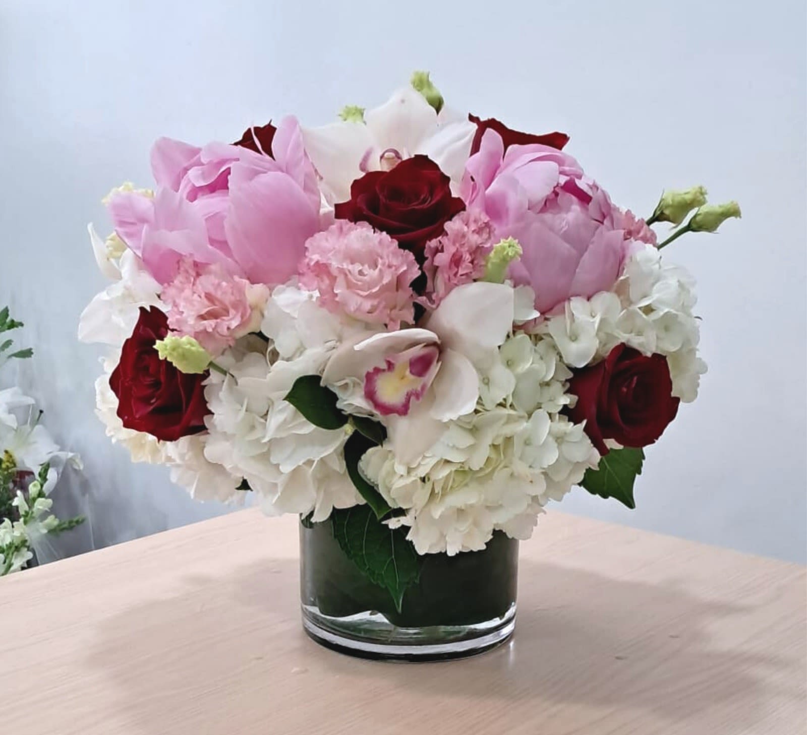 Pink and white bouquet with red roses in a glass vase