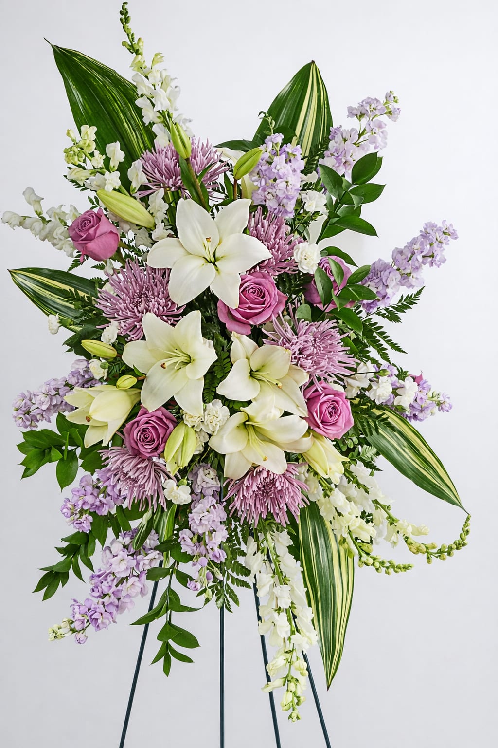 Tall floral spray with white lilies, pink roses, and lavender blooms